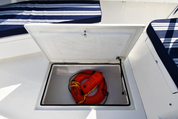 Open storage compartment on 2021 Eastern 248 Center Console boat with life ring.