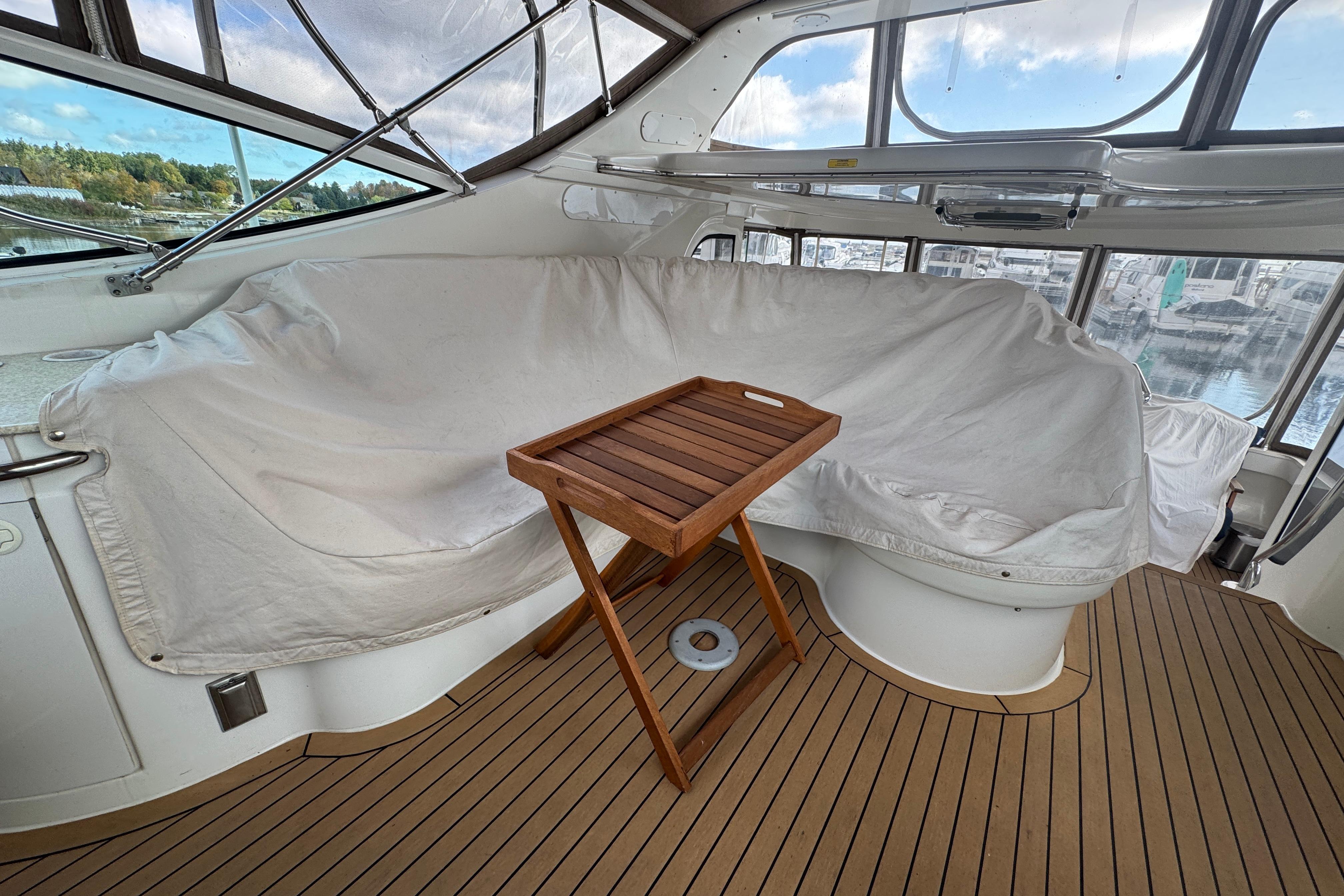 Interior of 2002 Carver 466 Motor Yacht with covered seating and wooden tray table.