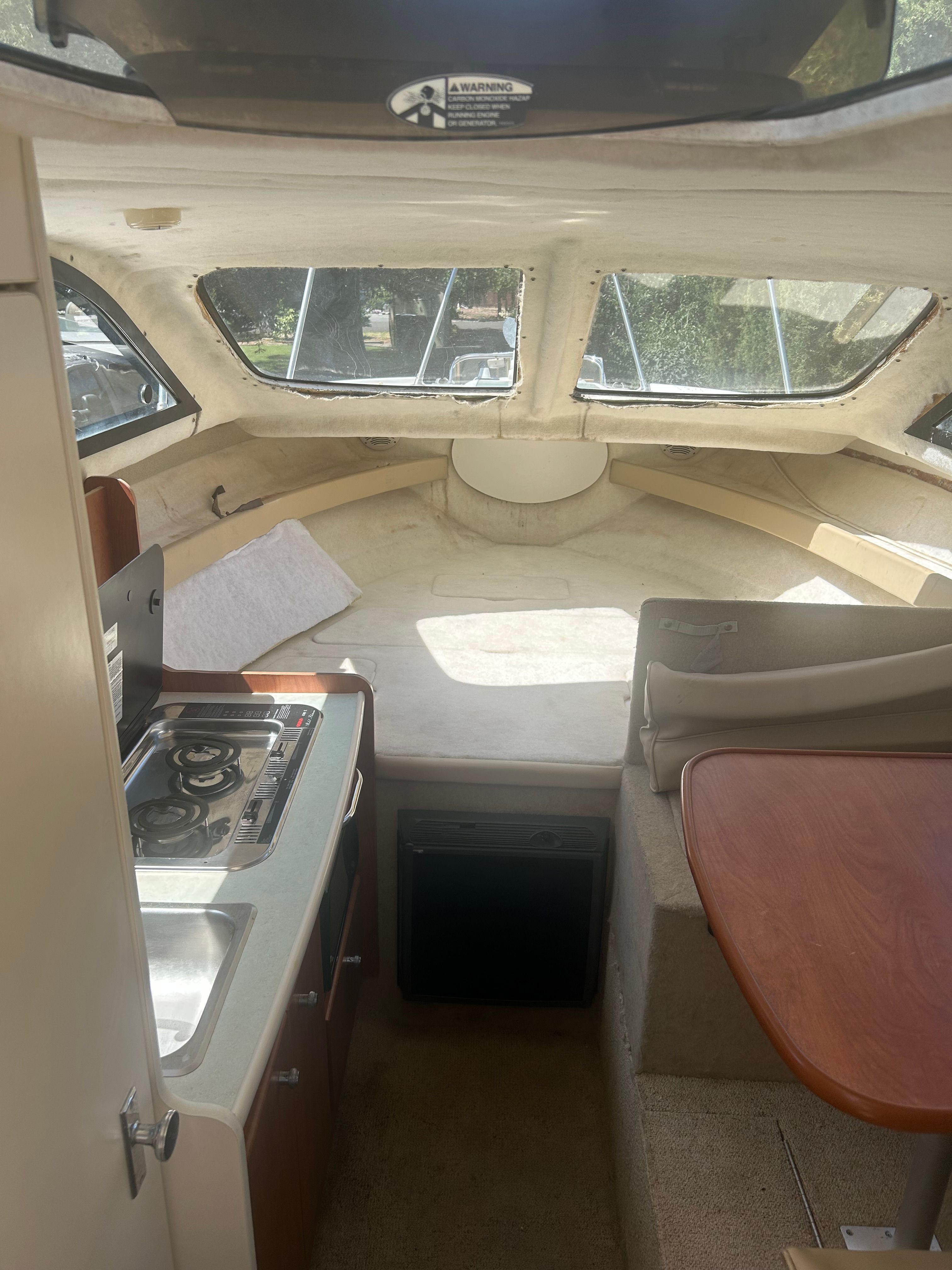 Interior of a 2005 Bayliner Classic 242 with kitchen and seating area.