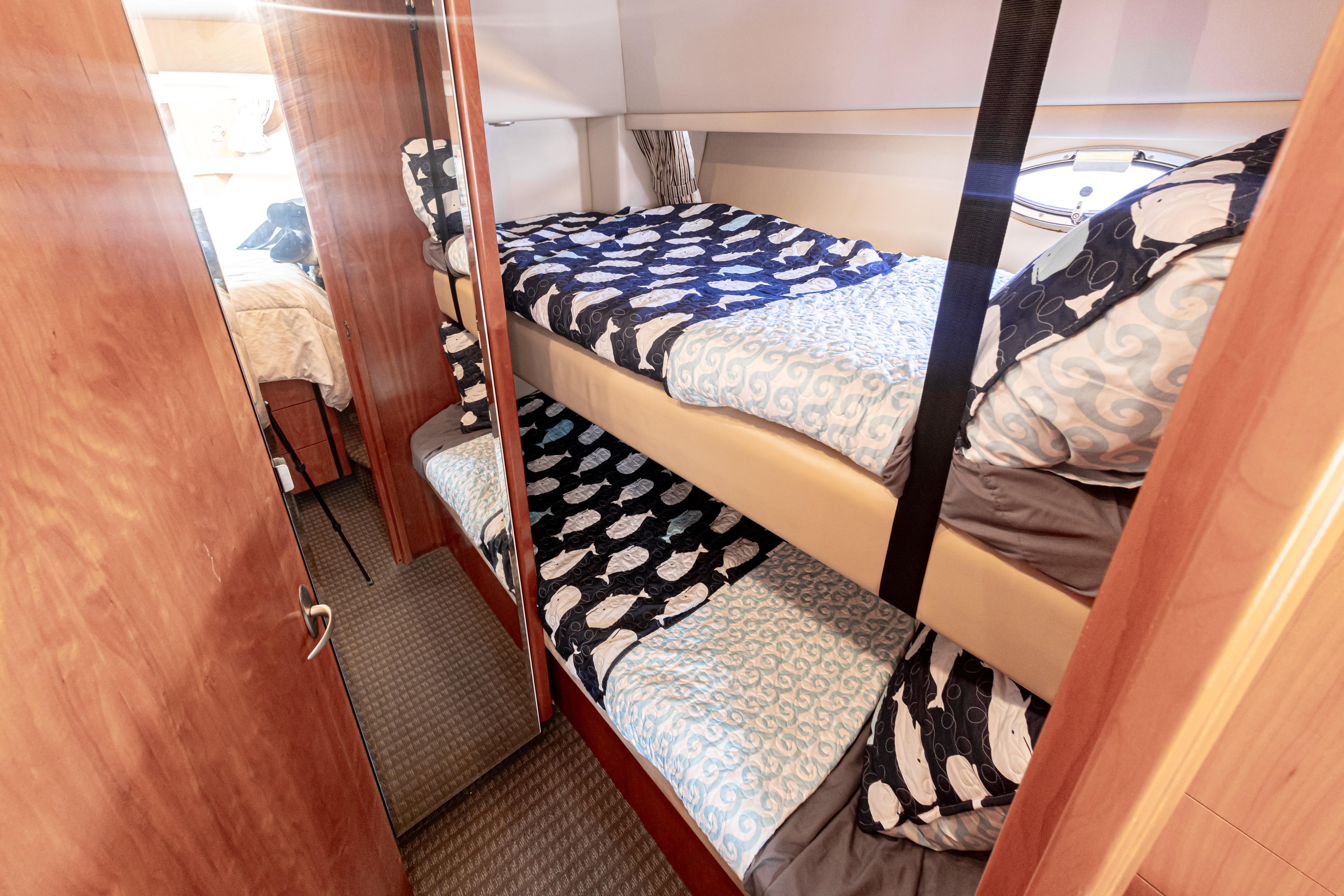 Bunk beds in 2004 Meridian 490 Pilothouse yacht cabin with nautical-themed bedding.