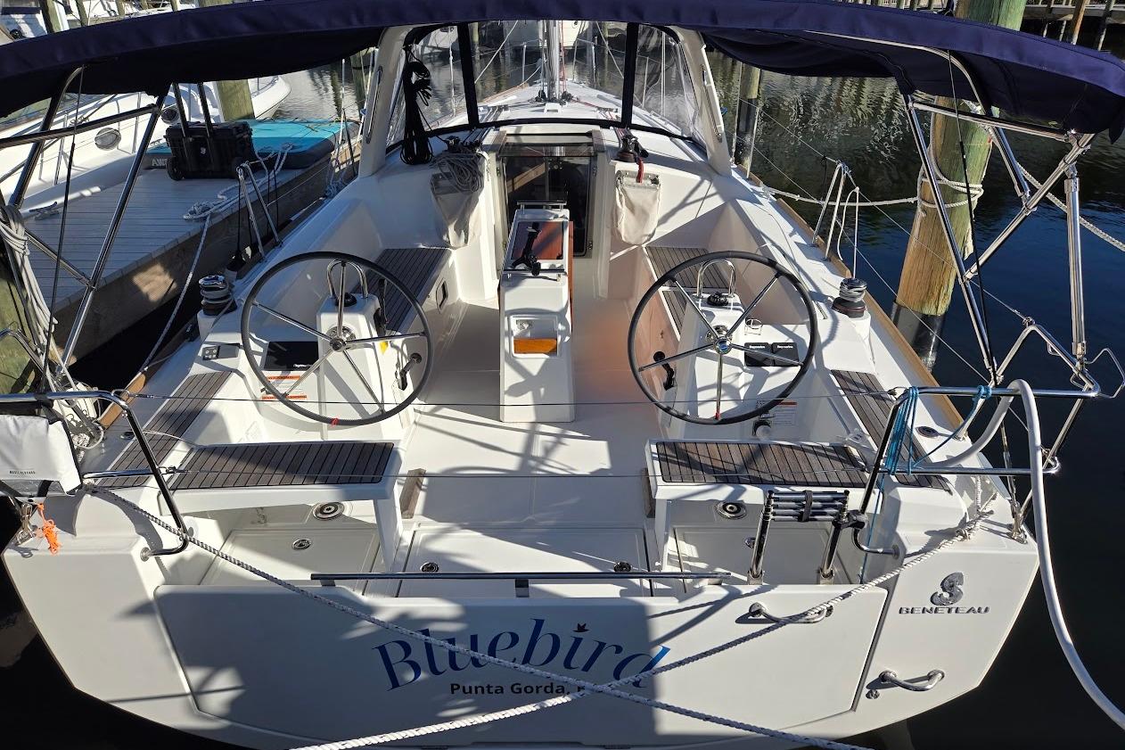 2023 Beneteau Oceanis 38.1 sailboat docked, featuring dual steering wheels and spacious cockpit.