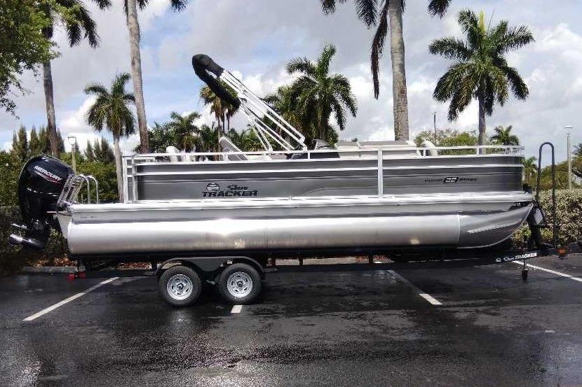 2026 Sun Tracker Fishin' Barge 22 DLX pontoon boat on trailer.