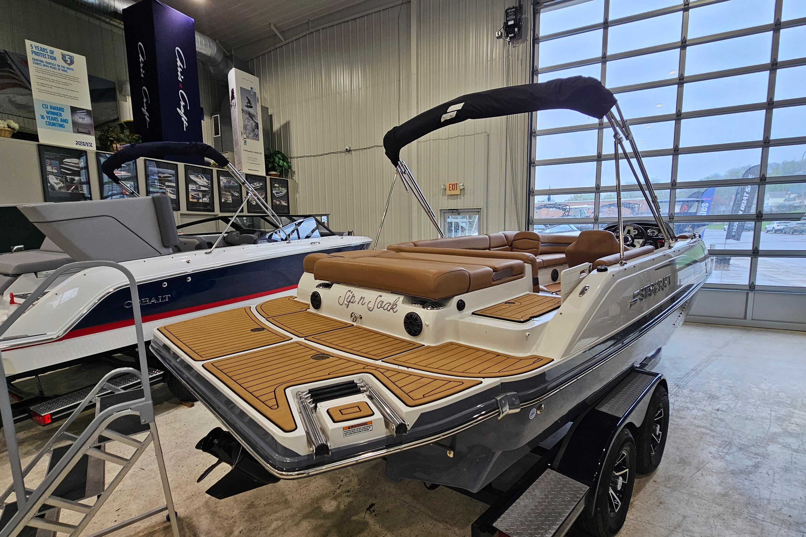 2022 Starcraft Star Step 221 E I/O boat displayed in showroom with sleek design.