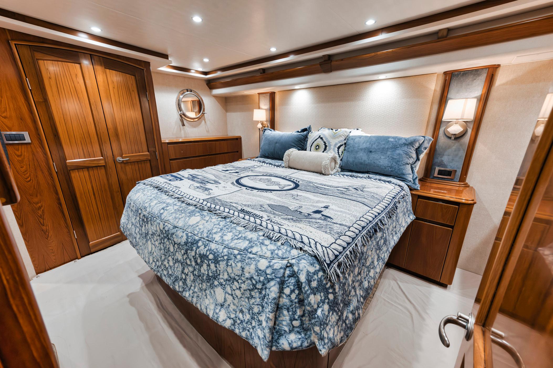 Luxurious bedroom interior of 2015 Viking 70 Convertible yacht with elegant wood finishes.