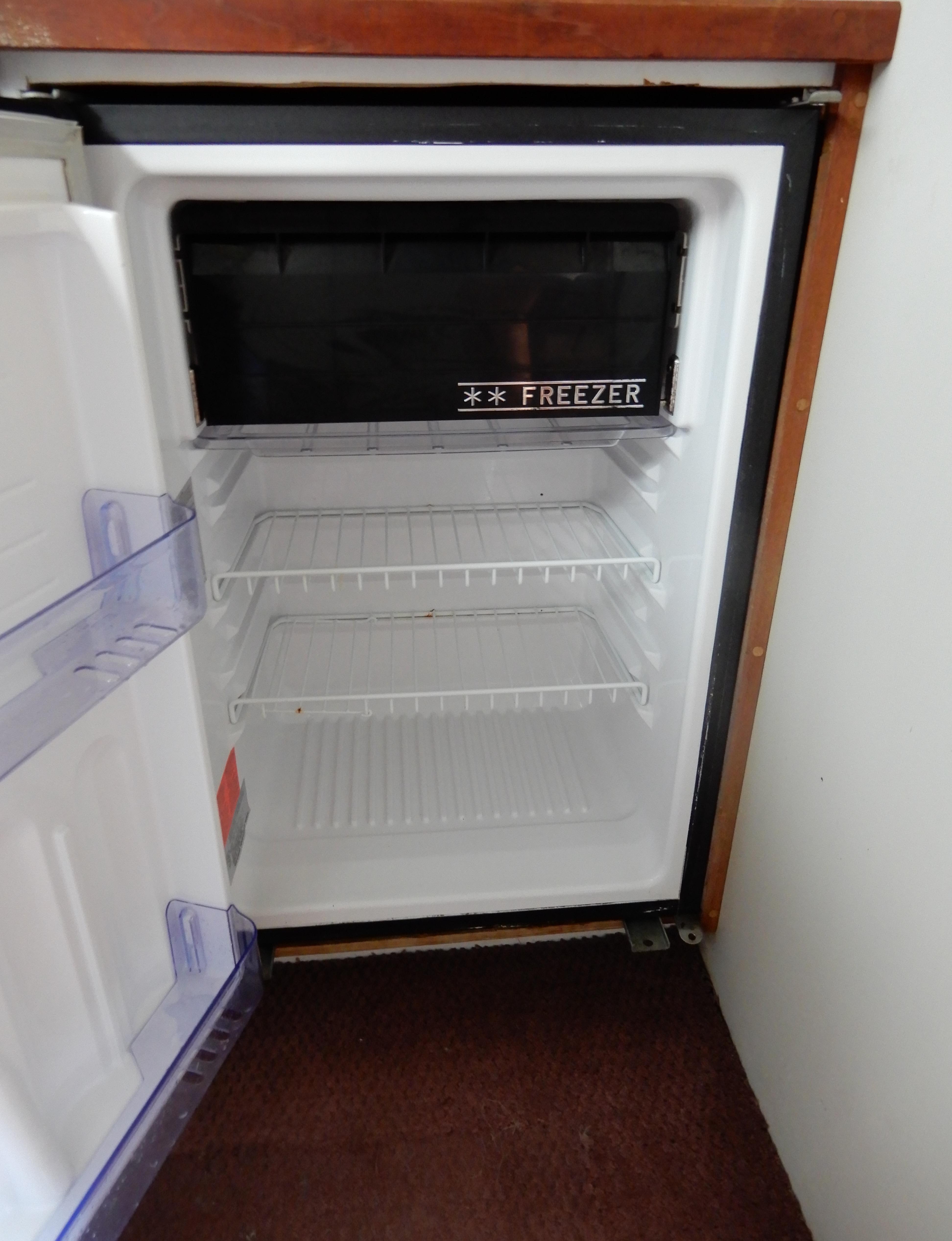 Empty refrigerator with freezer in 1987 Carver 28 Mariner Voyager boat.