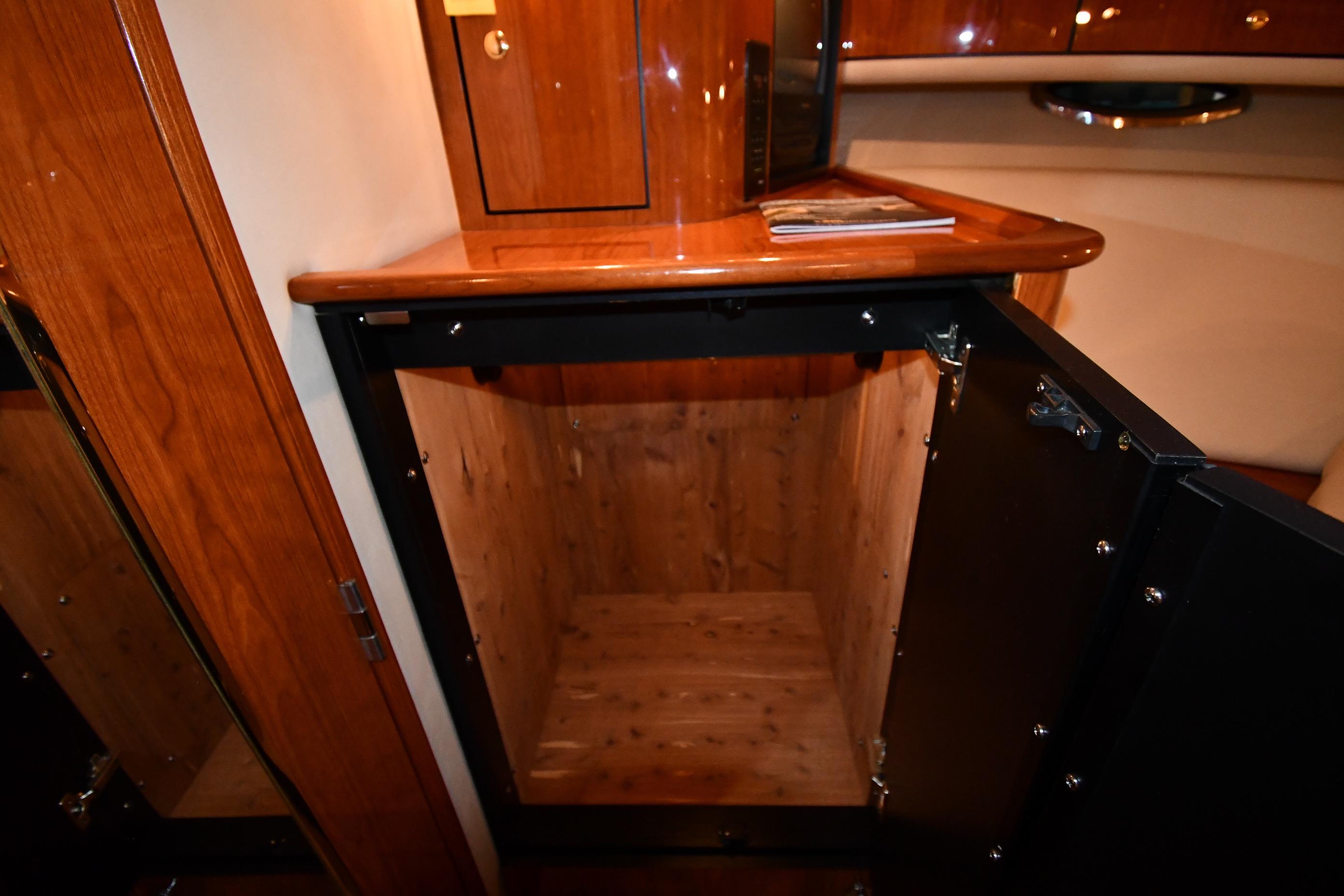 2001 Sea Ray 540 Sundancer interior with open wooden cabinet and polished surfaces.