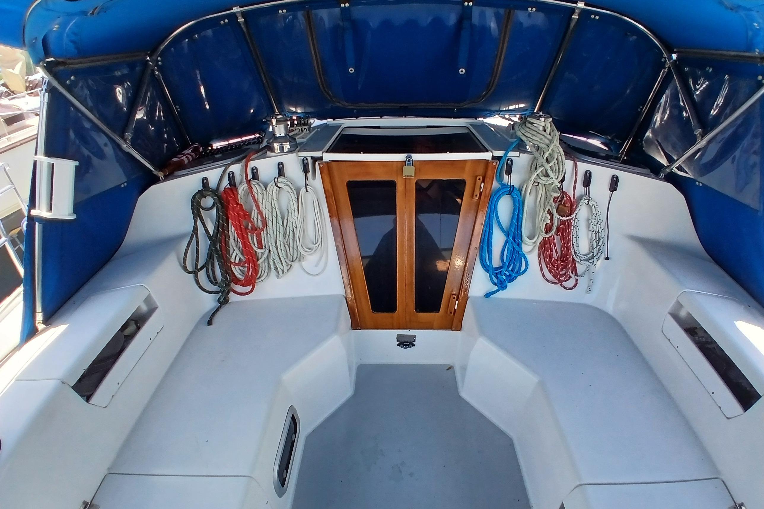 Cockpit of a 1995 Catalina 42 MkII sailboat with ropes and wooden hatch.