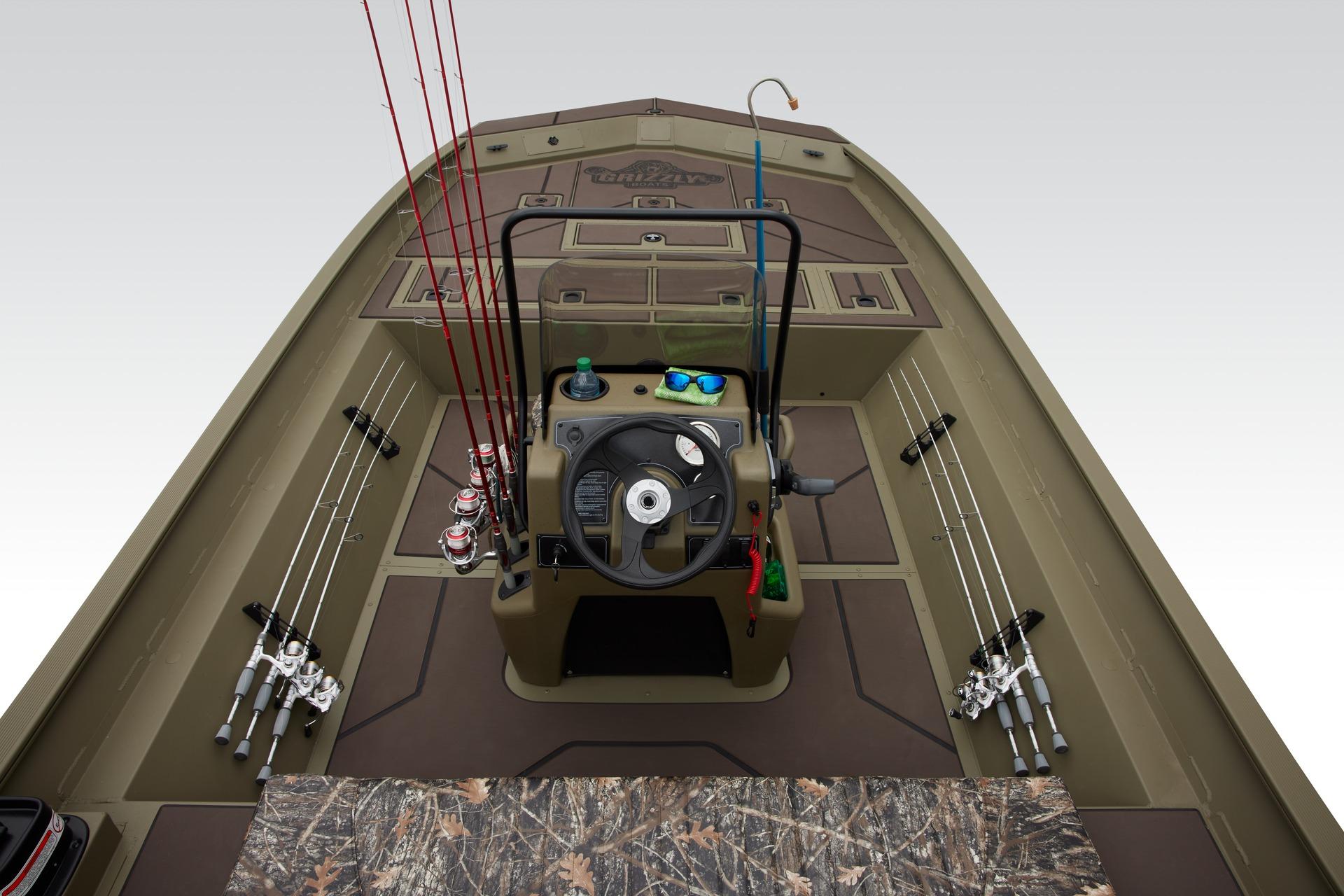 2025 Tracker Grizzly 2072 CC boat interior with fishing rods and steering console.