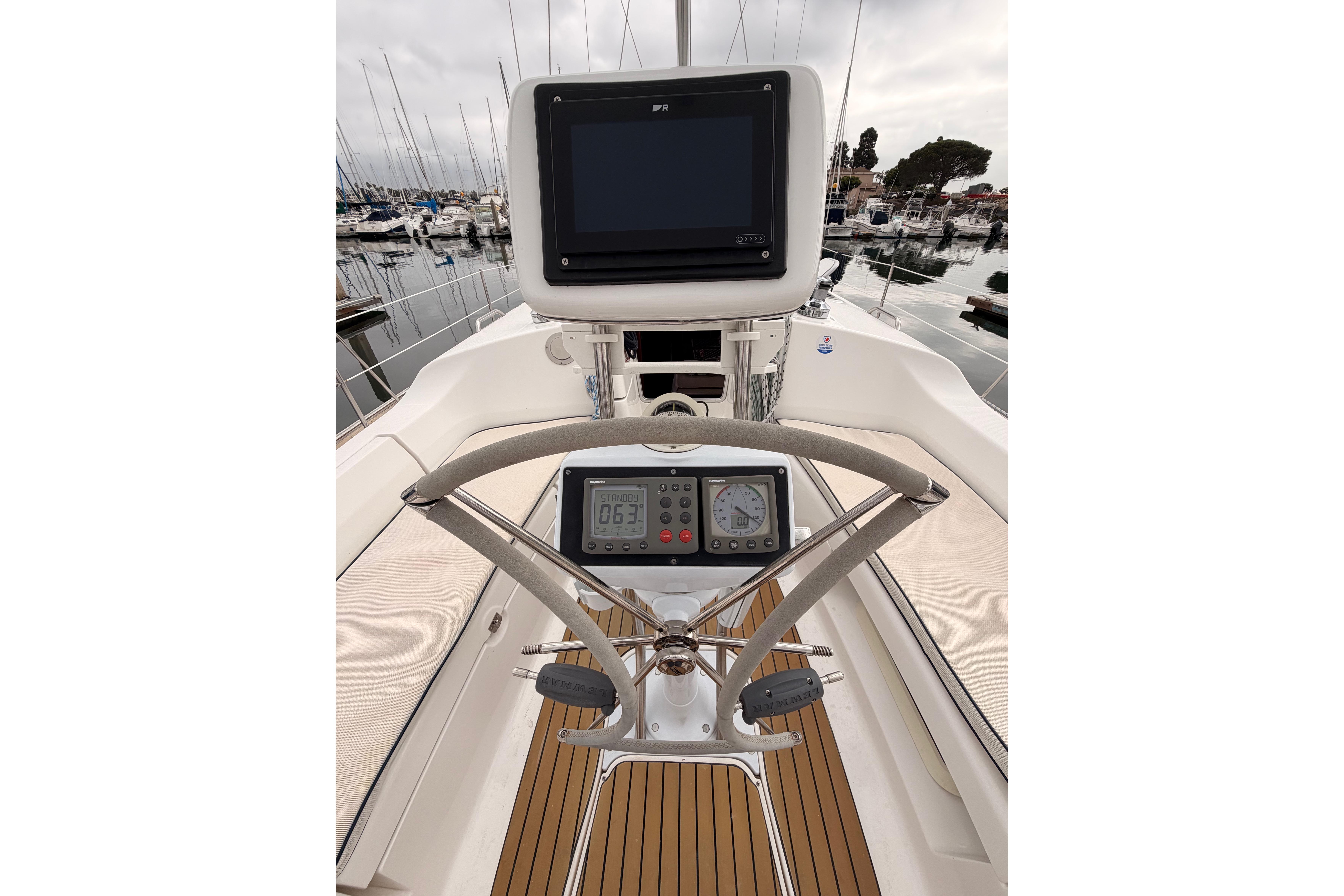 Cockpit view of 2009 Hunter 38 sailboat with navigation equipment and steering wheel.