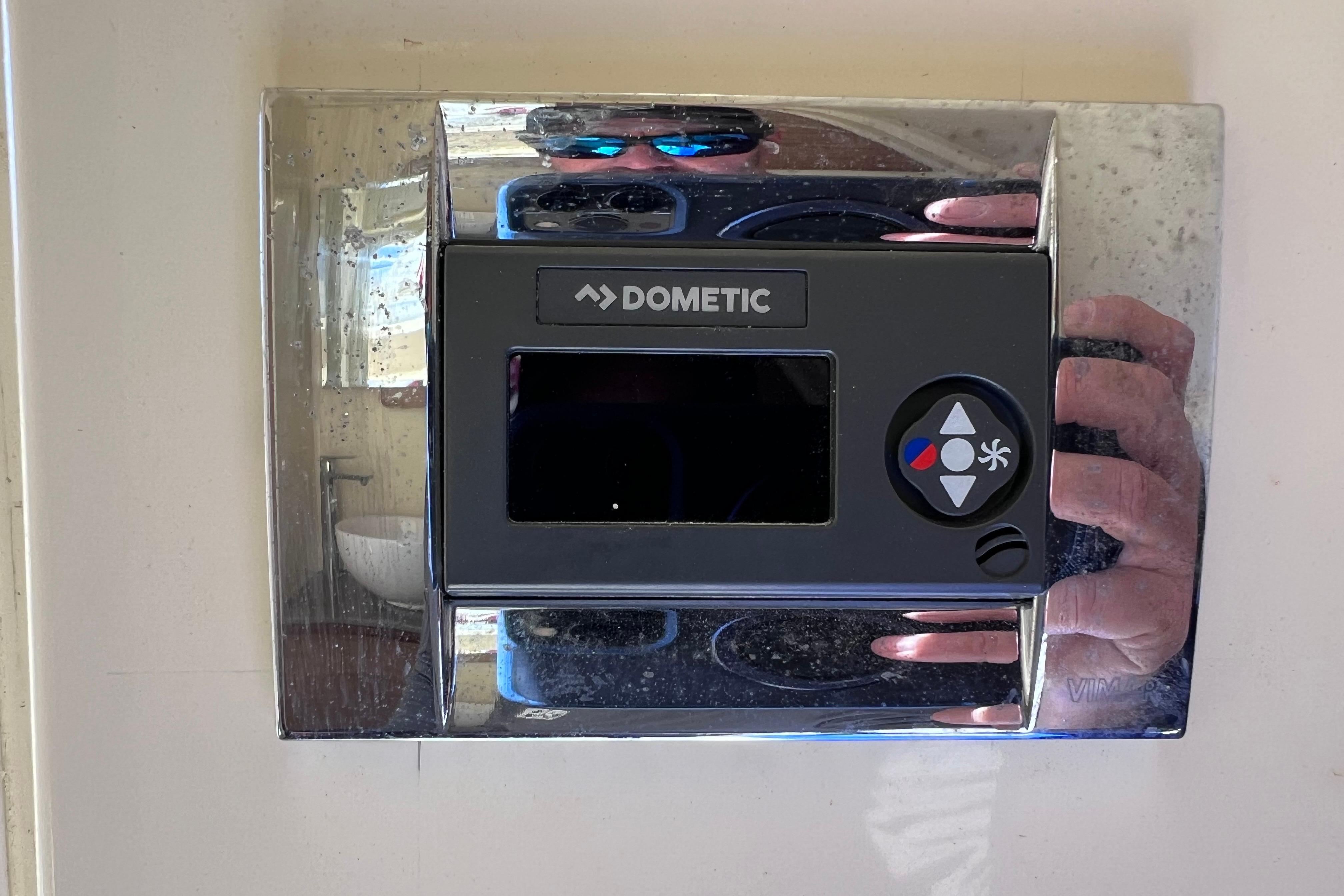 Dometic control panel on 2022 Chris-Craft Catalina 30 boat, reflecting surroundings.