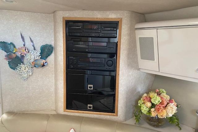 Entertainment system in a 1995 Regal 402 boat interior with floral decor and fish wall art.