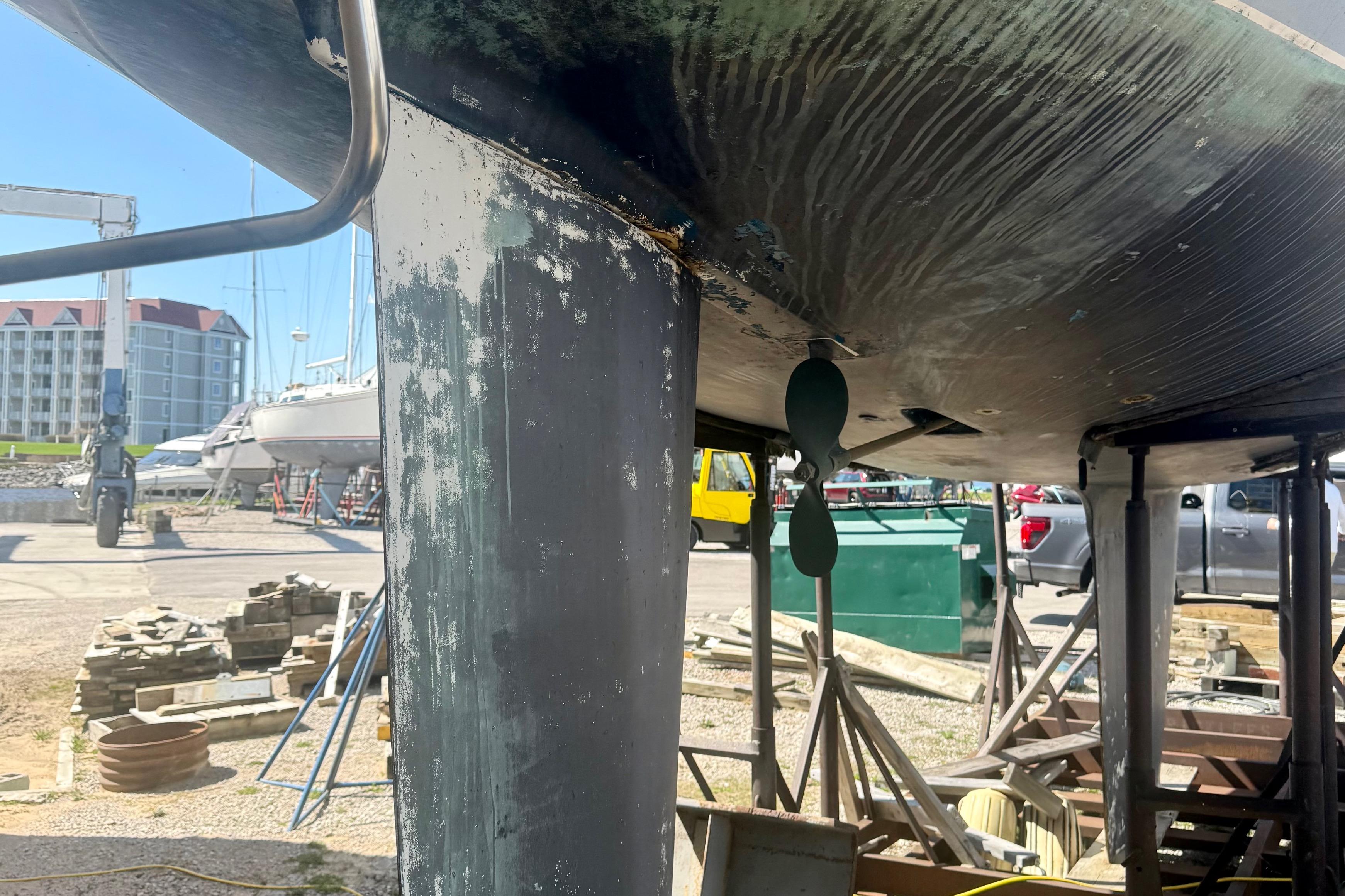 1987 Hunter Legend 35 sailboat under maintenance, showing keel and propeller in a boatyard.