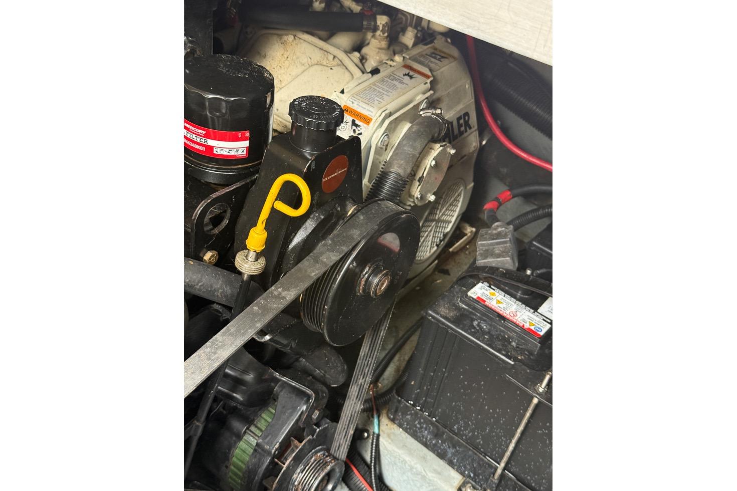 Engine compartment of a 1999 Sea Ray 290 Sundancer boat, showing belts and components.