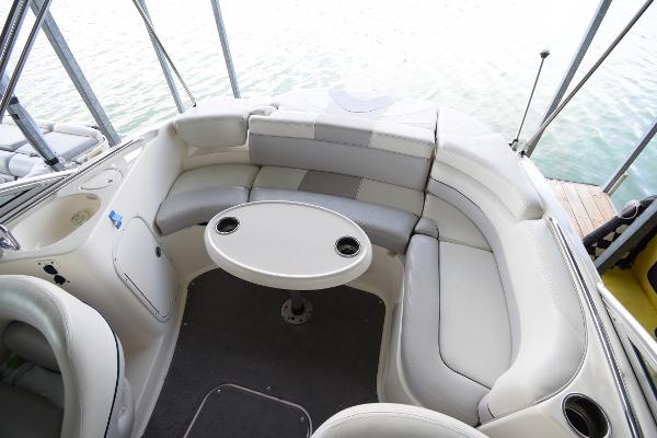 The image shows the cockpit of a 2010 Bryant 255 boat with white cushioned seating.