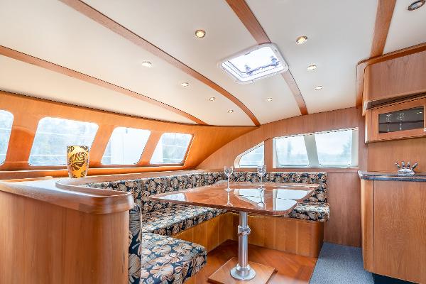 Luxurious interior of 2025 Shuttleworth 52 AeroRig yacht with elegant wood finish and seating.