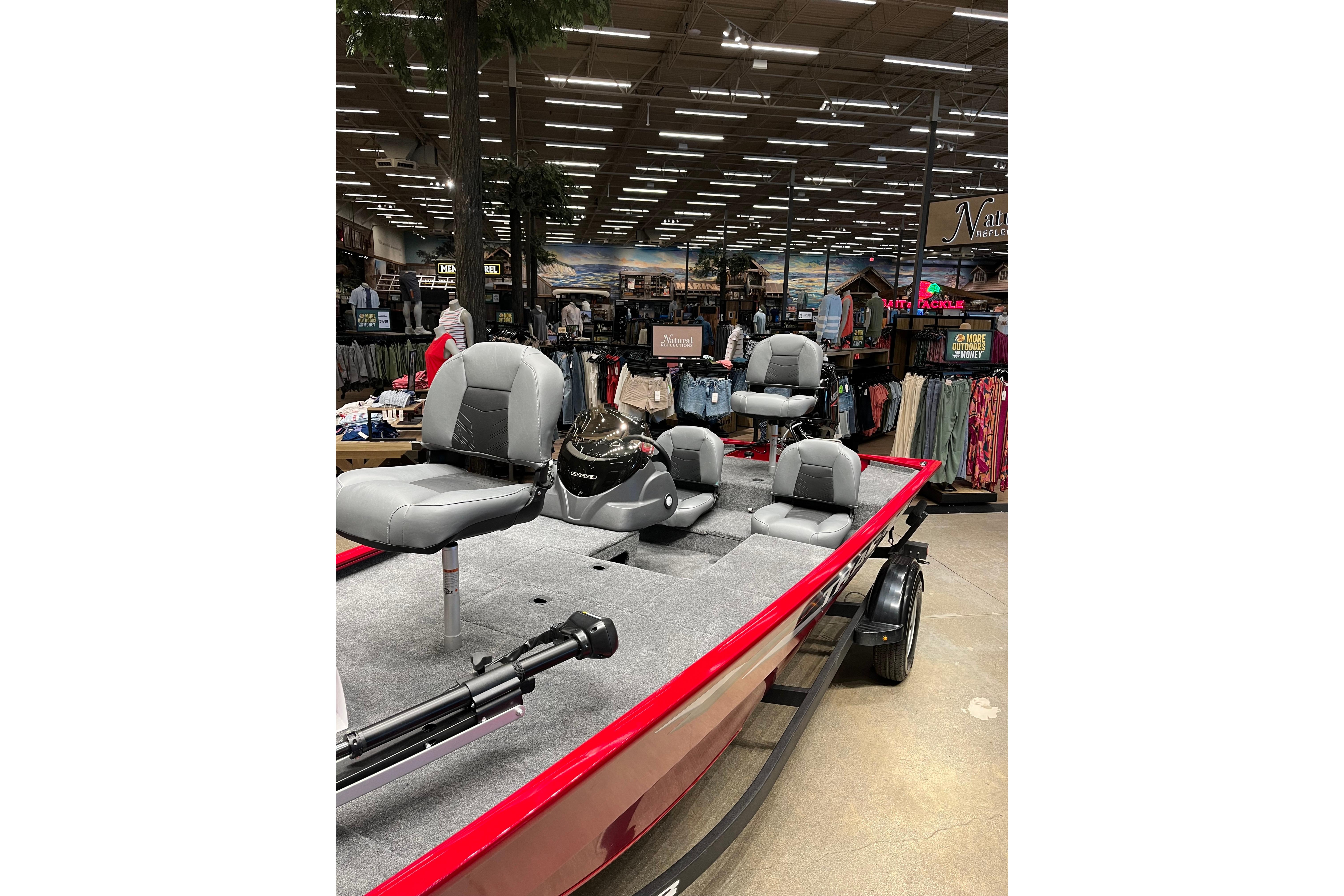 2026 Tracker Pro 170 boat displayed in a store, featuring gray seating and red exterior.