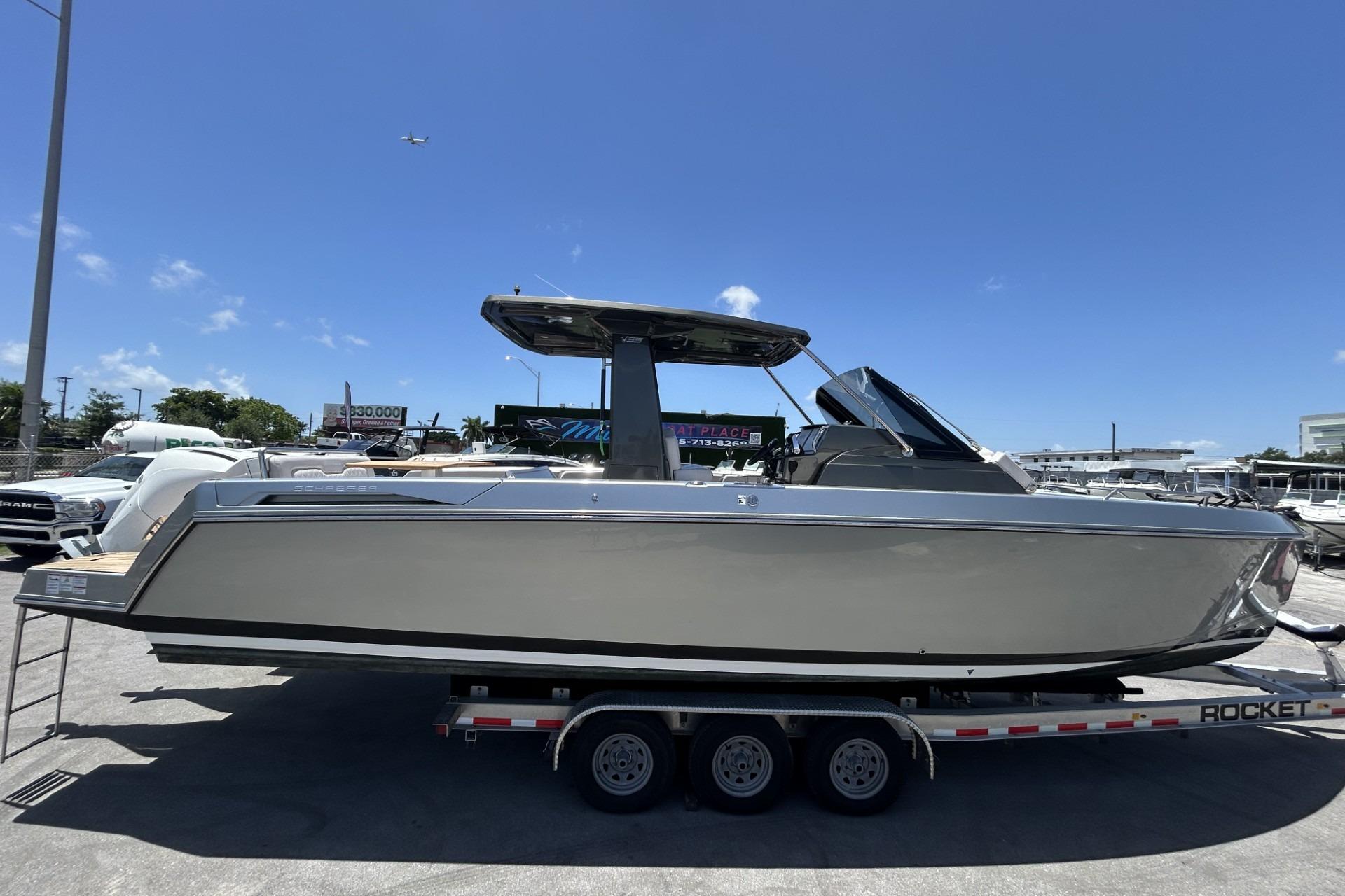 2023 Schaefer V33 boat on trailer under clear blue sky.