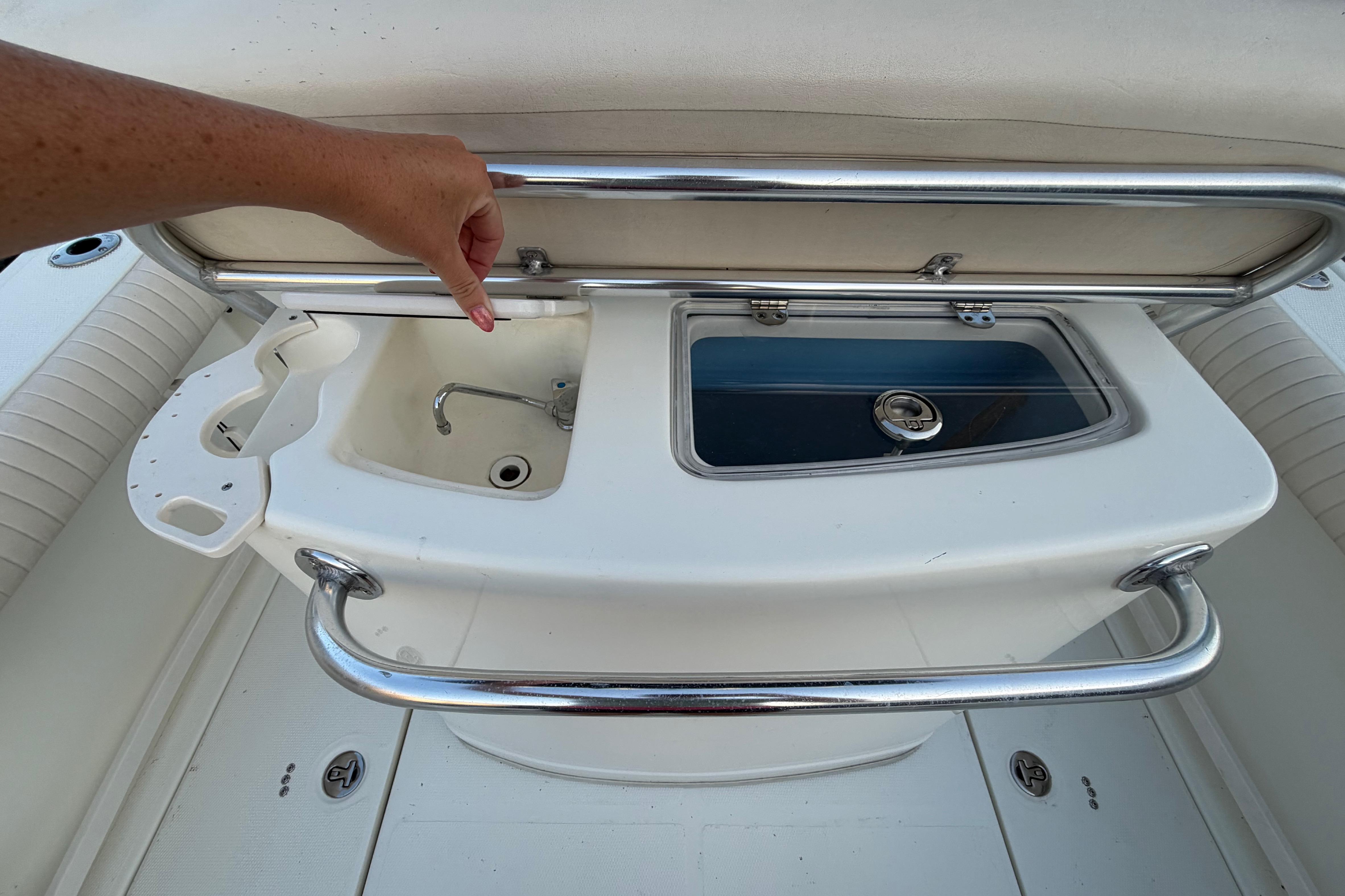 2007 Mako 234 Center Console boat with sink and storage compartment.