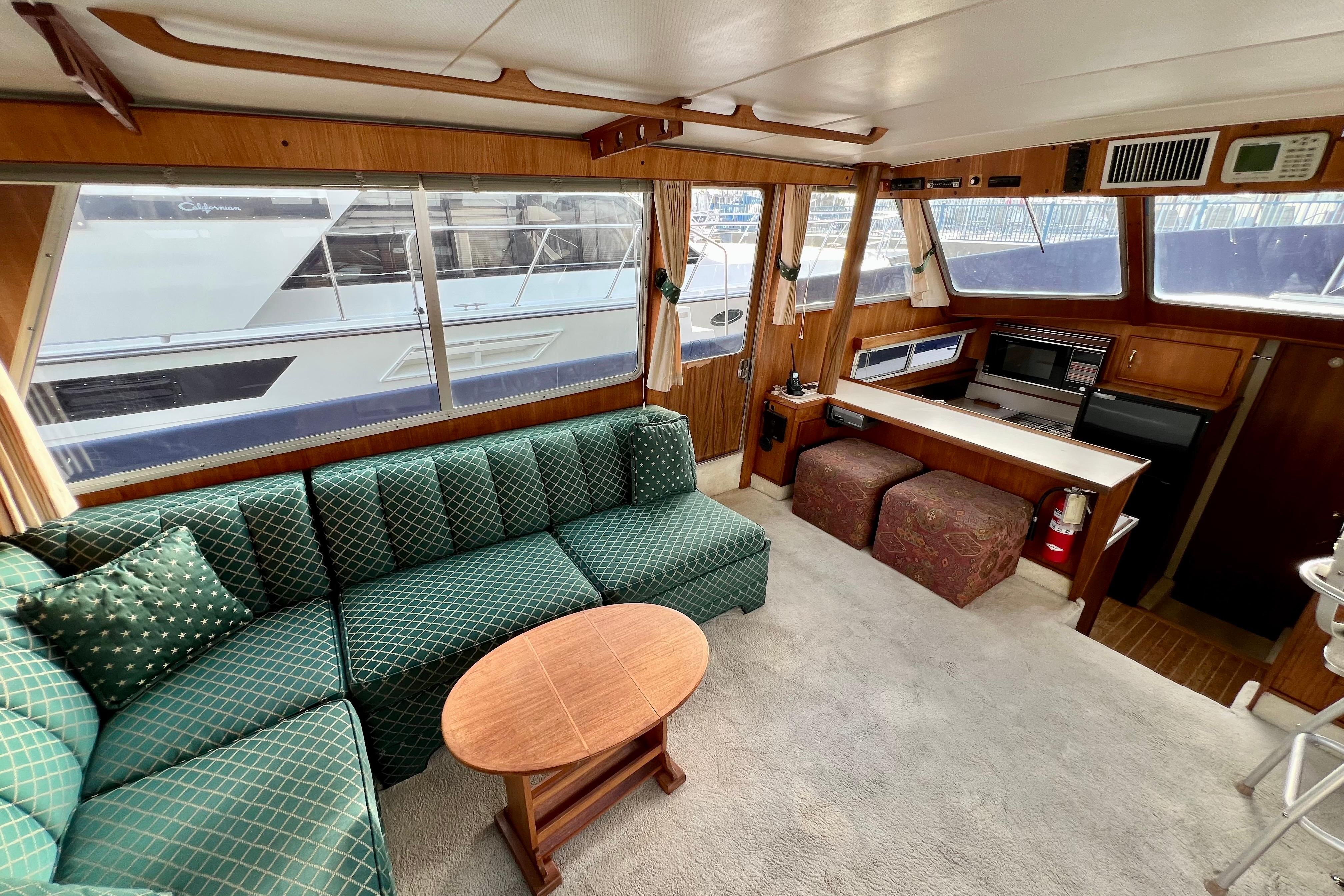 Interior of 1985 Tollycraft 48 Cockpit Motor Yacht with green sofa and wooden accents.