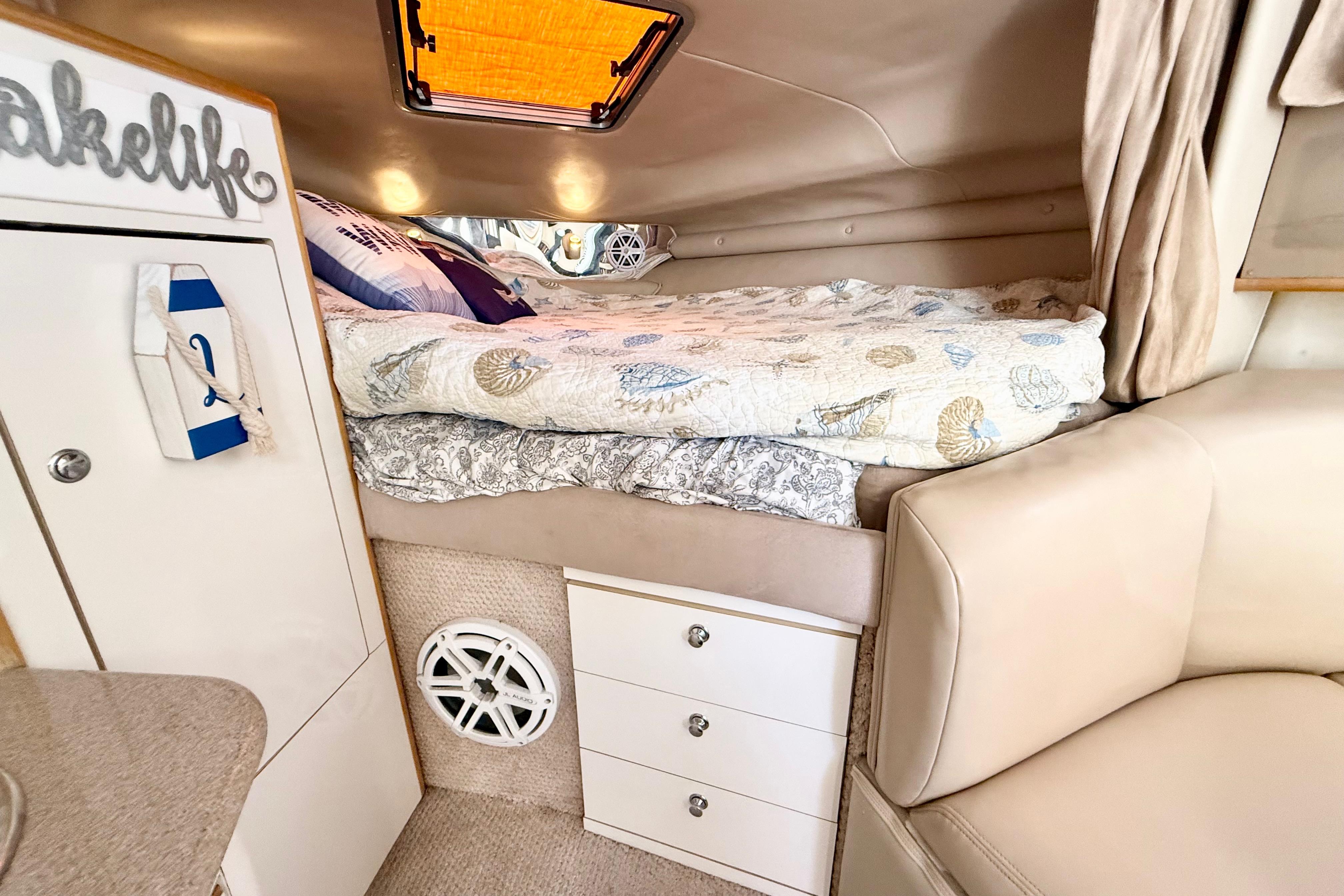 Interior of 1999 Chaparral Signature 300 boat with cozy bed and storage drawers.