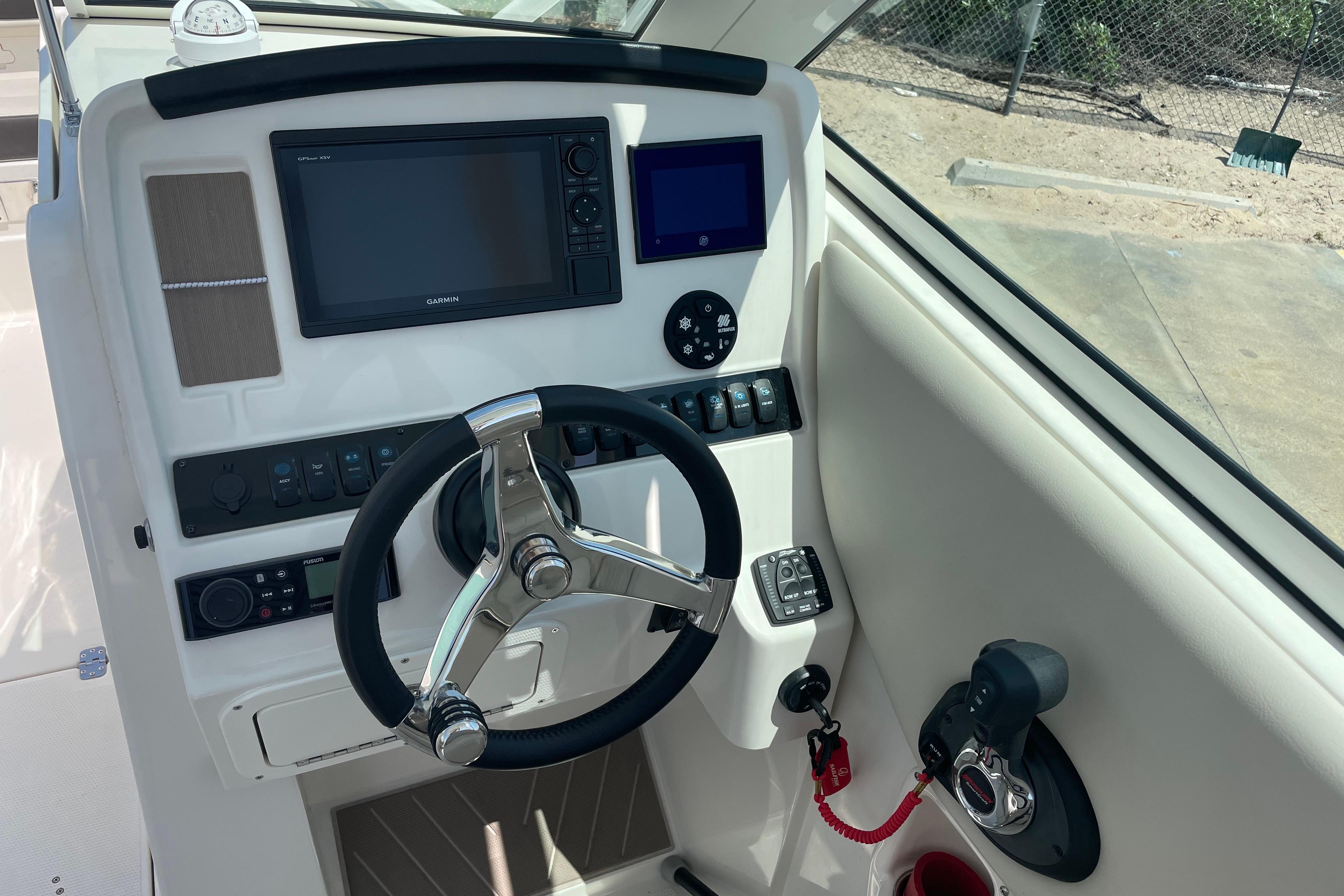 2022 Sailfish 245 DC boat dashboard with steering wheel and navigation controls.