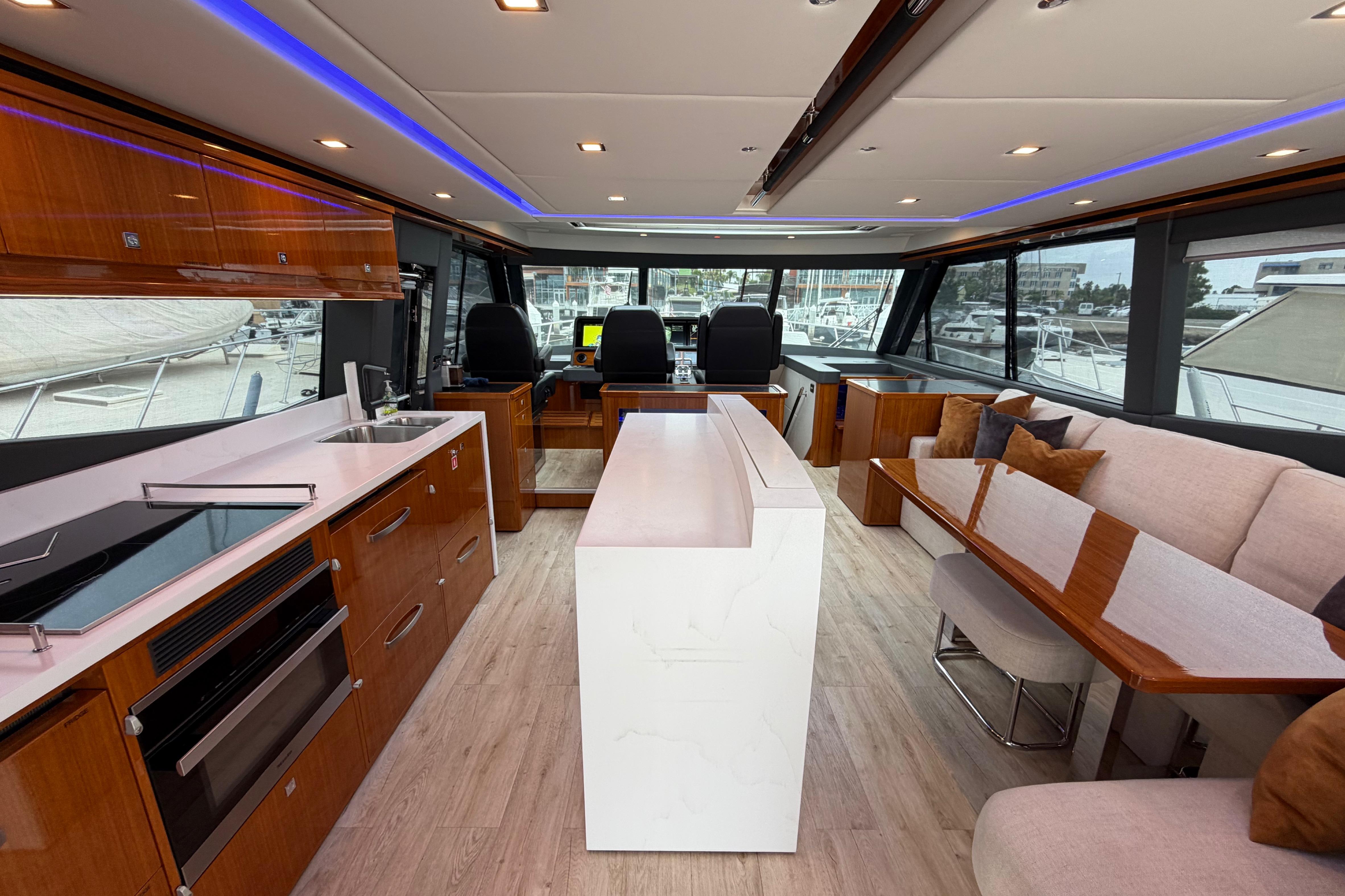 Luxurious interior of 2023 Riviera 645 SUV yacht with modern kitchen and seating area.
