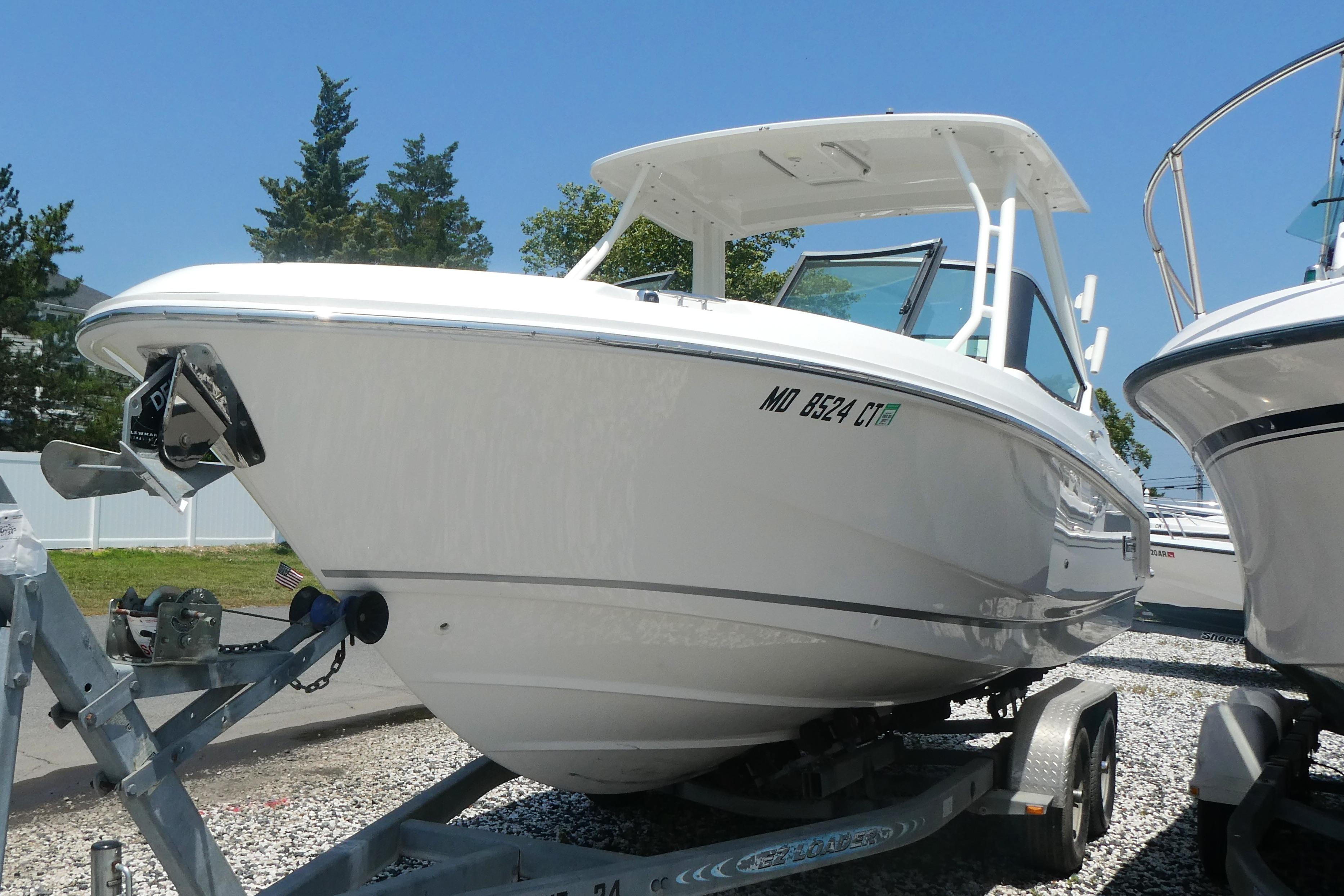 2022 Boston Whaler 240 Vantage boat on trailer, parked outdoors under clear blue sky.