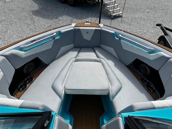 2022 Nautique S23 boat interior with cushioned seating and cup holders.