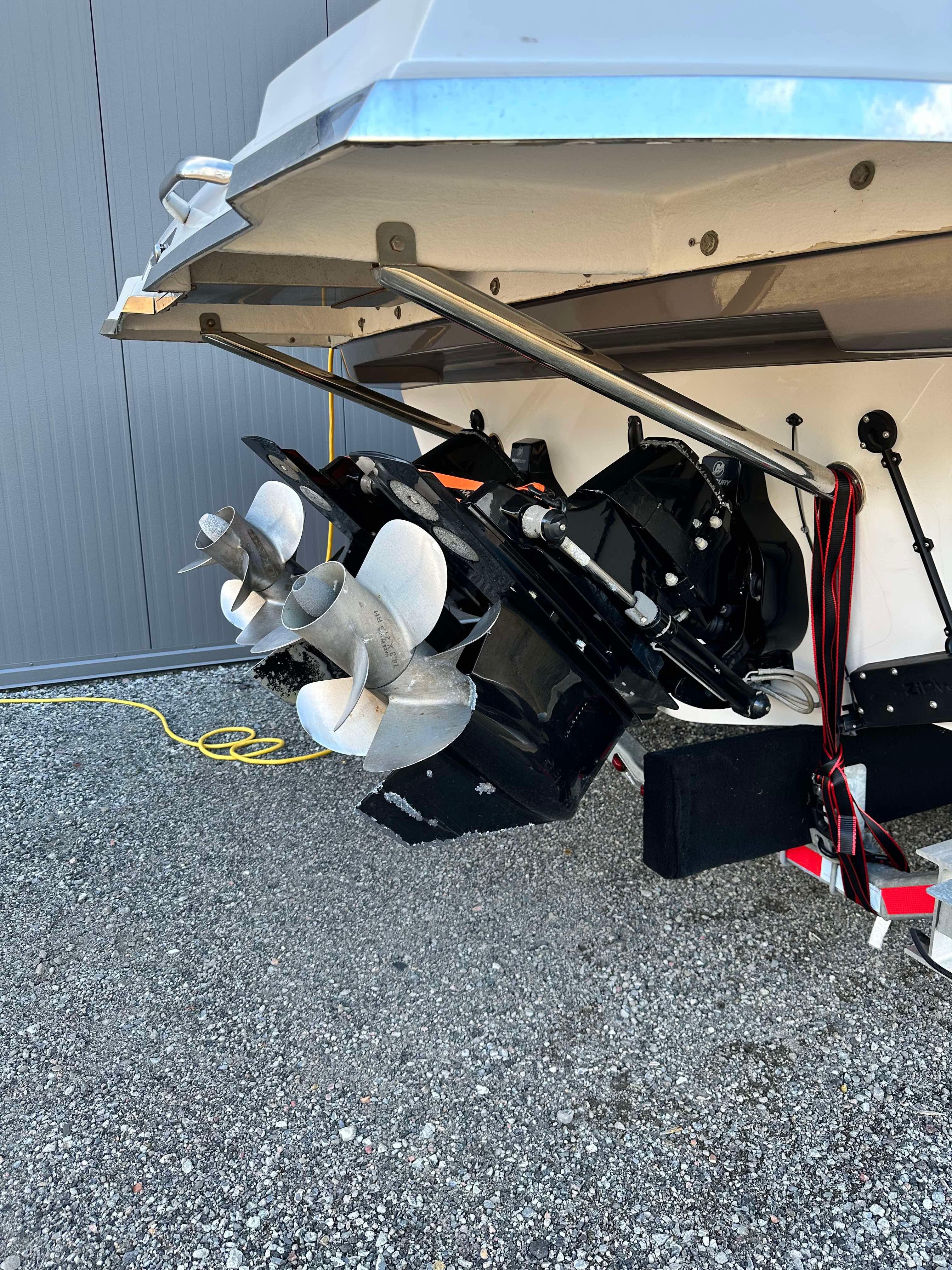 2021 Cobrey 33 HT boat stern with dual propellers on gravel surface.