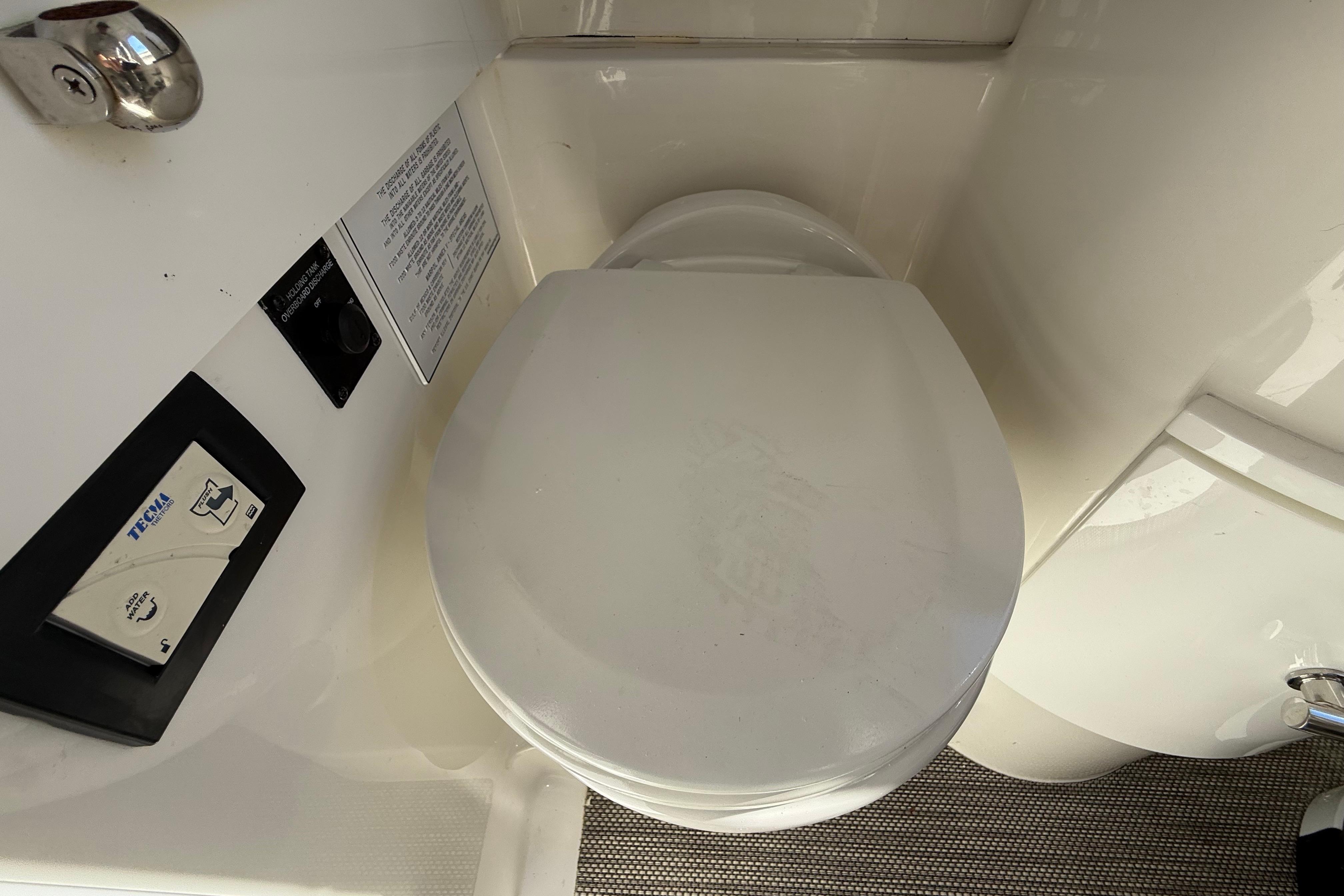 2022 Regulator 34 boat bathroom with Tecma marine toilet and control panel.