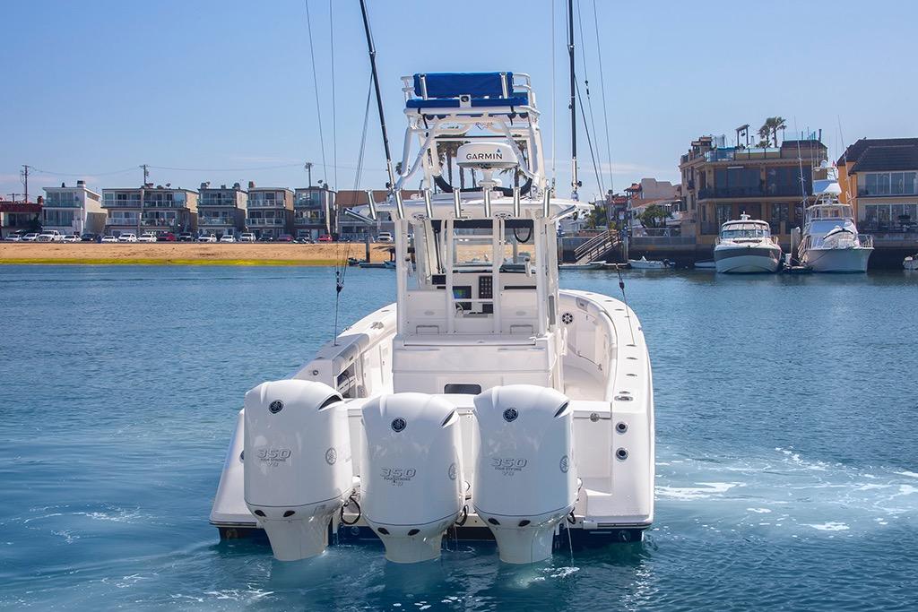 2013 Everglades 355 Center Console boat with triple engines in a marina setting.