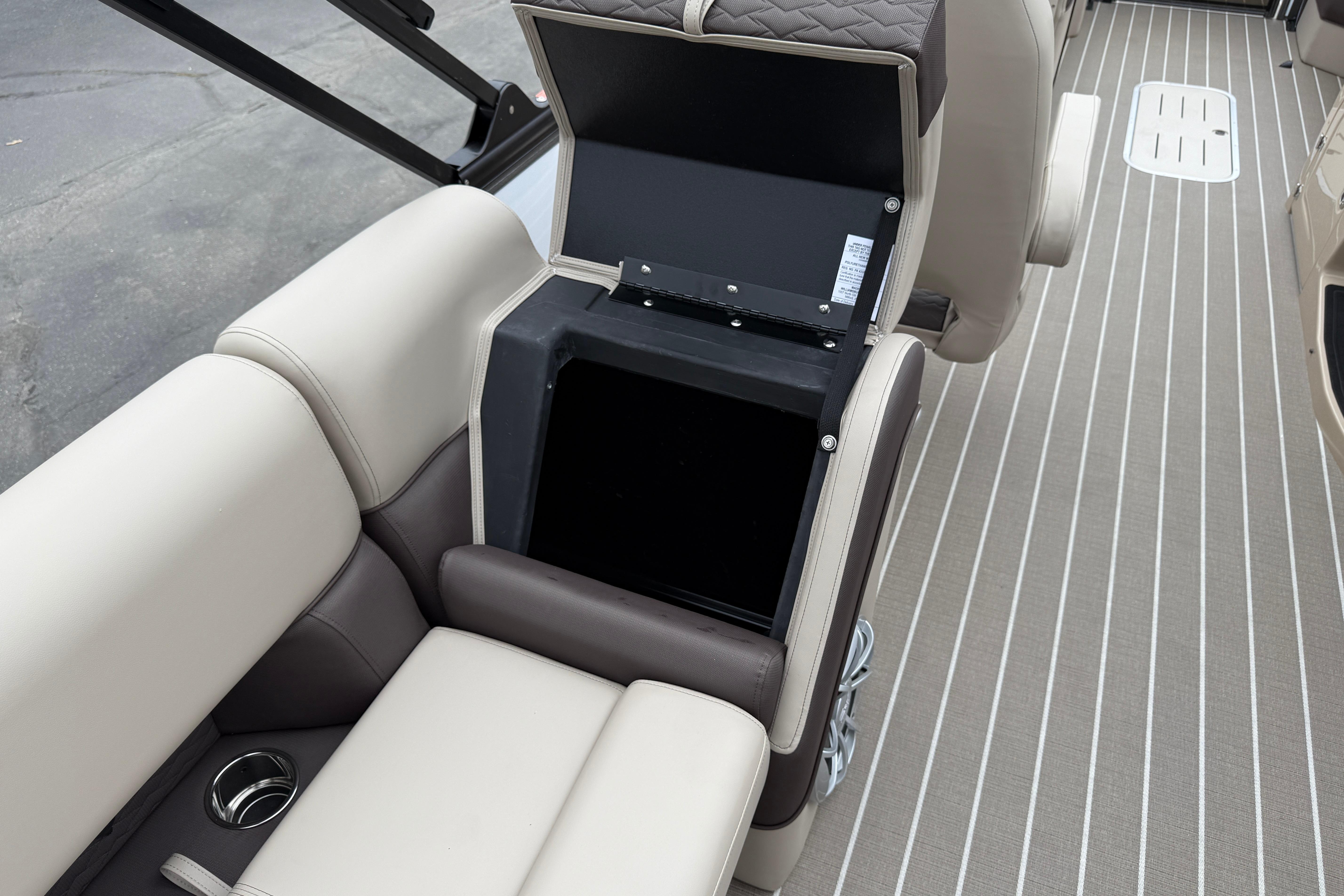 2026 Bentley Pontoons Elite 253 Admiral interior storage compartment with beige seating and striped flooring.
