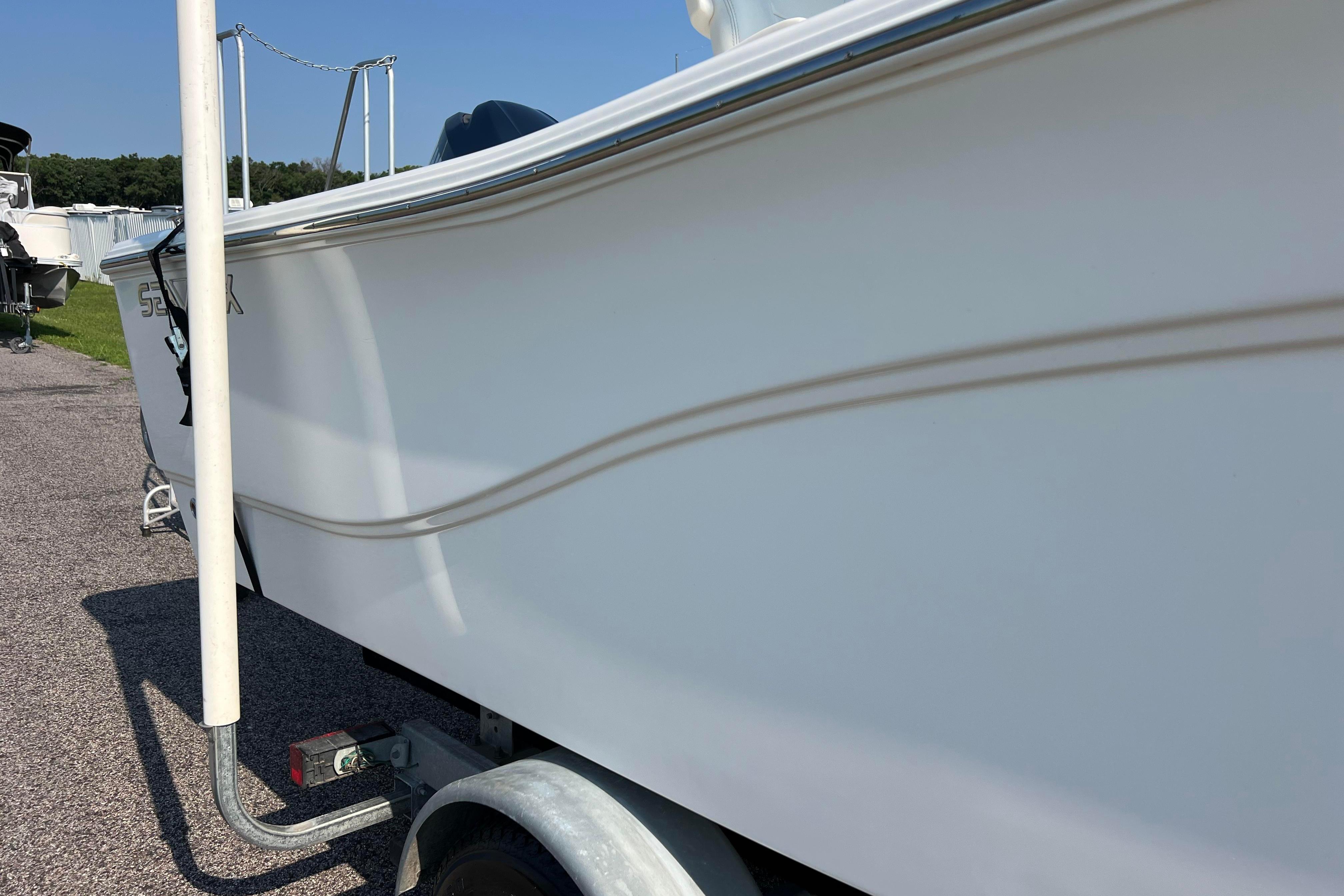 2012 Sea Fox 206 Center Console boat on trailer, side view in outdoor setting.