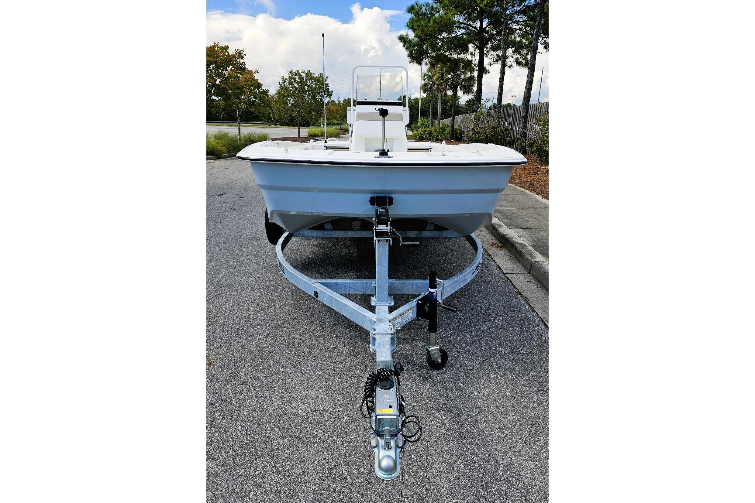 2026 Mako Pro Skiff 19 CC on trailer, parked on a paved road.