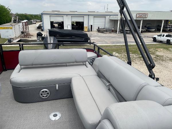 2023 Regency 250DL3 pontoon boat with gray seating, docked near a service area.