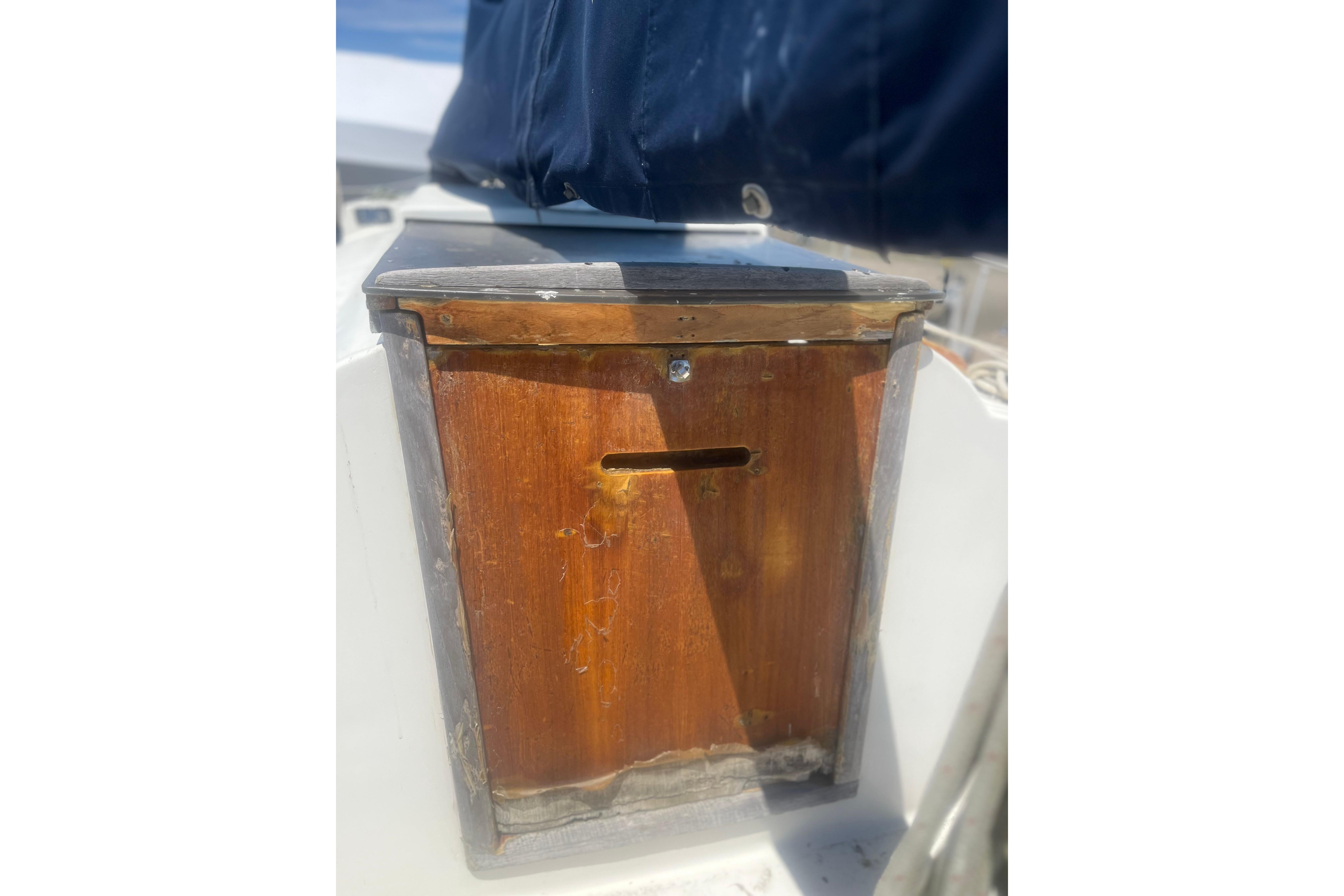 Wooden hatch on a 1972 C&C 30 sailboat, partially covered with a blue tarp.