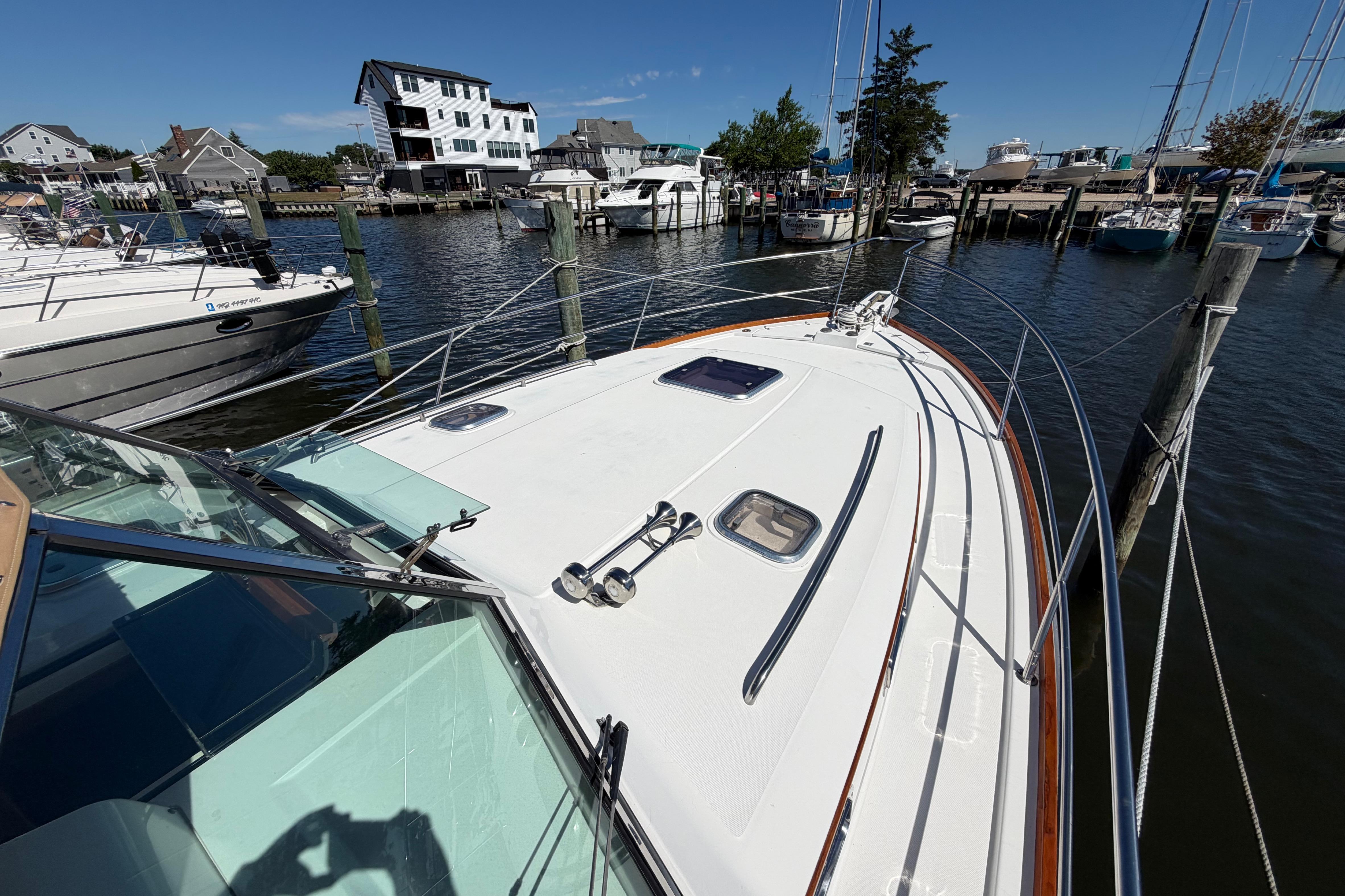 2000 Sabreline 36 Express yacht docked at a marina, surrounded by other boats.