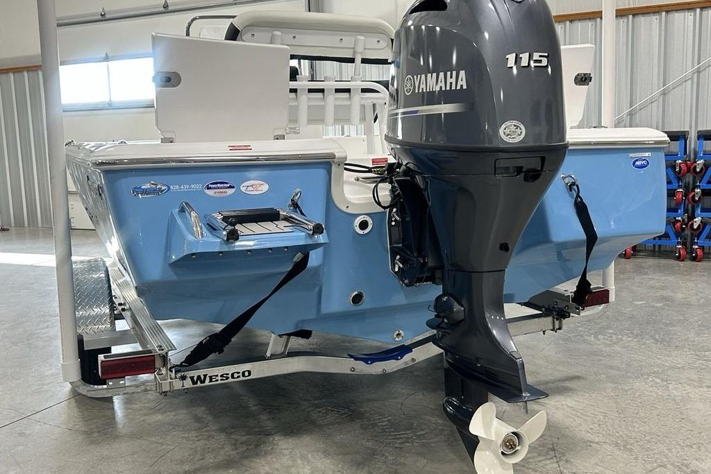 2026 Tidewater 1910 Bay Max boat with Yamaha 115 engine in a garage.