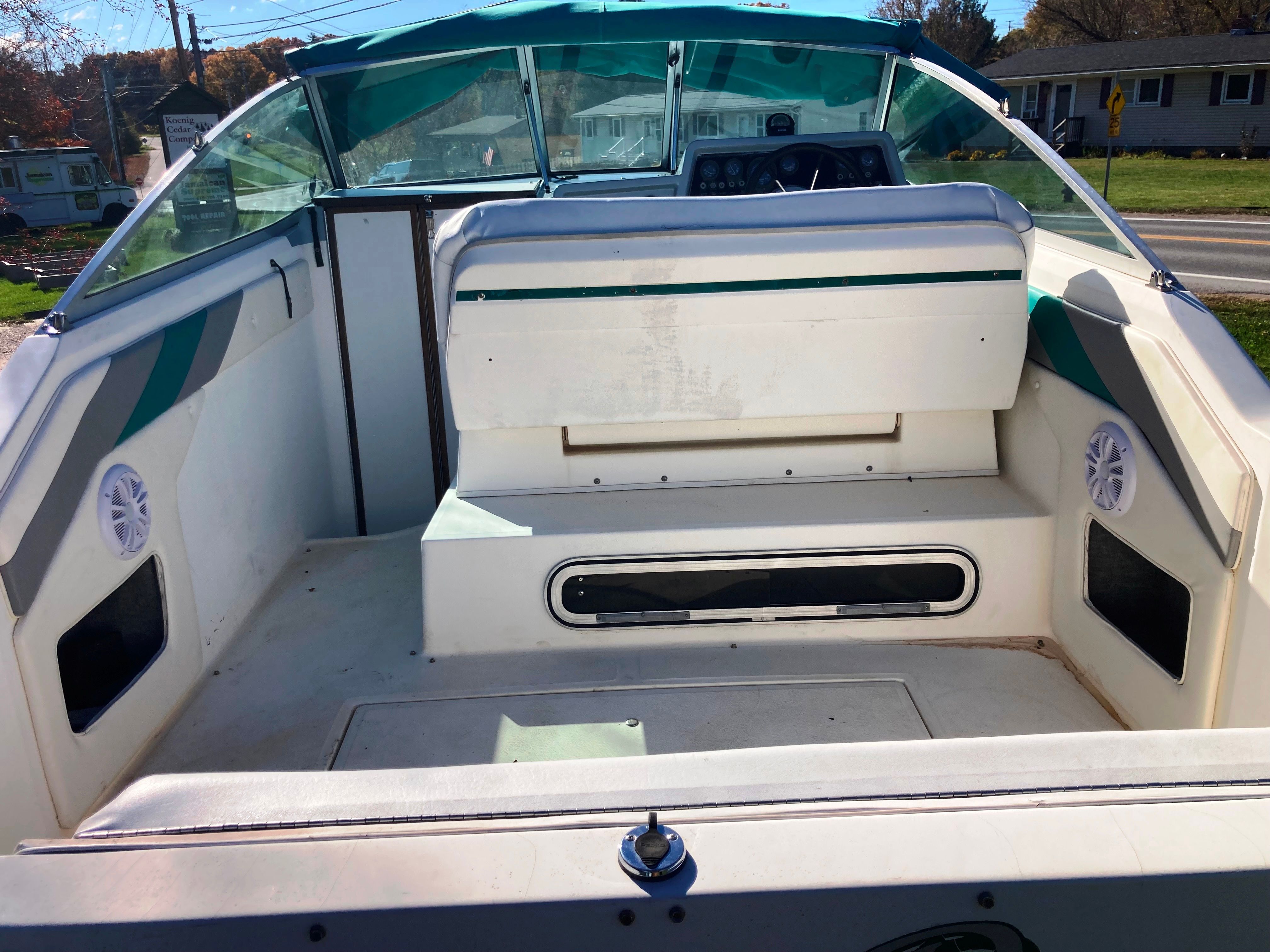 The image shows the cockpit of a 1991 Sea Ray 220 Sundancer with white seating and green accents.