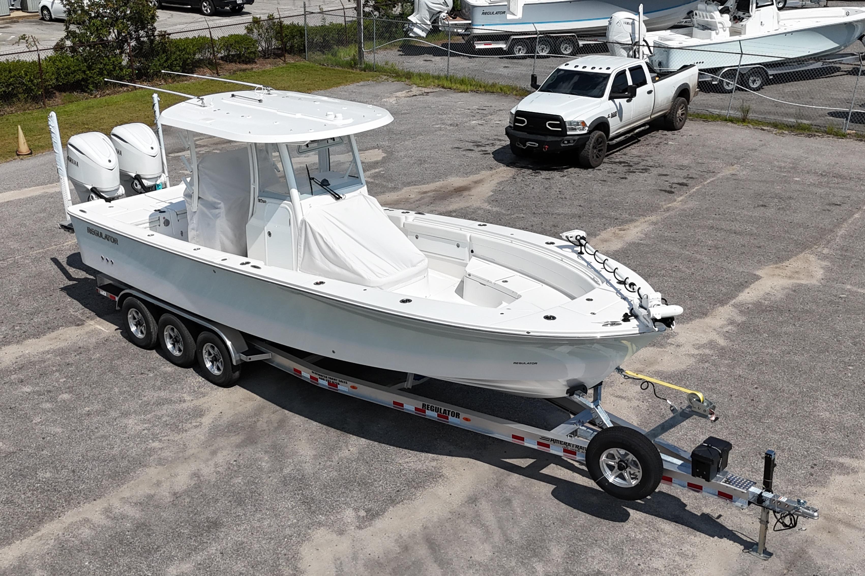 2026 Regulator 30XO boat on trailer, parked in a lot with a truck nearby.