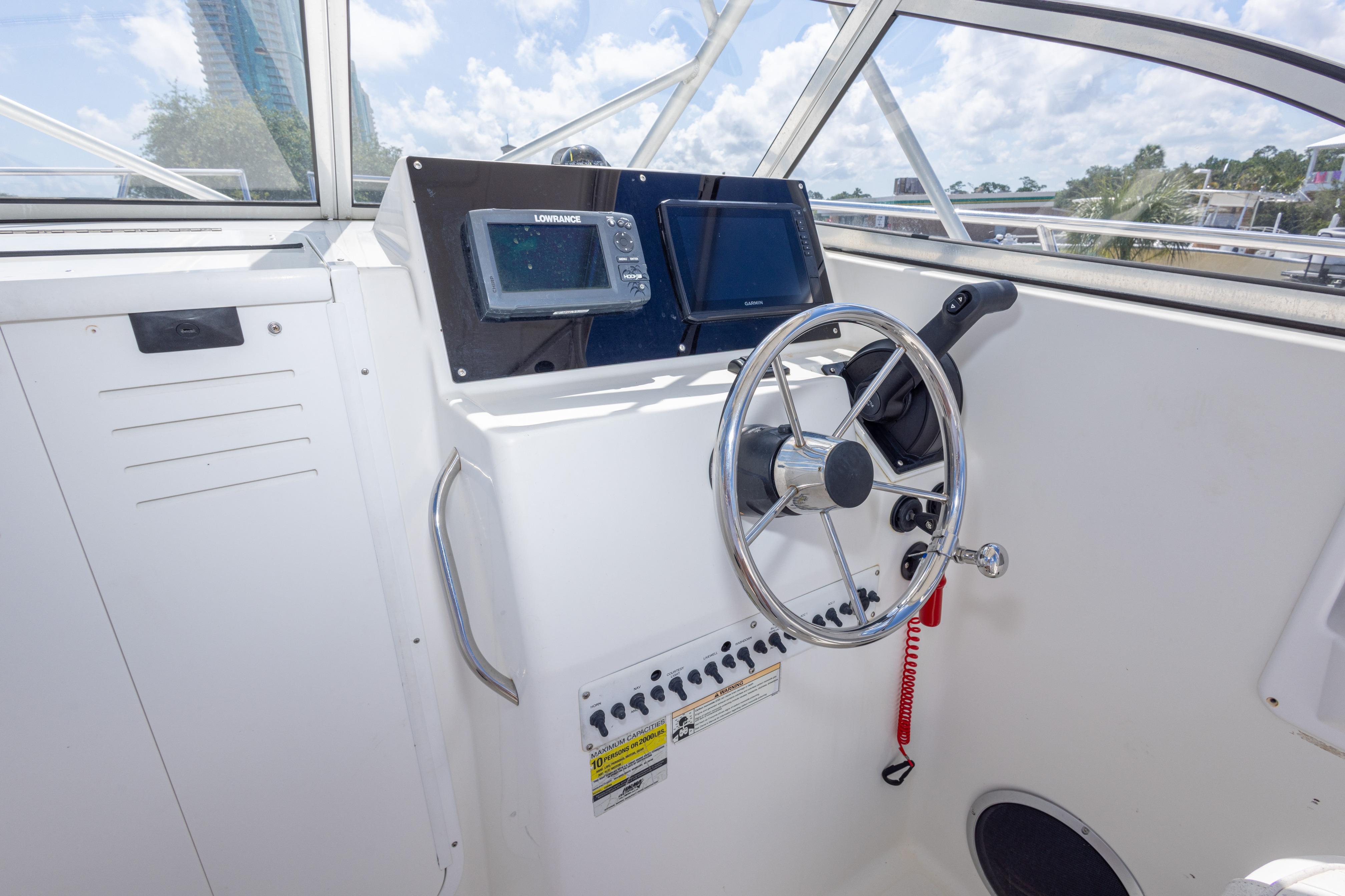 2007 Sea Boss 235 Walkaround helm with steering wheel and navigation equipment.