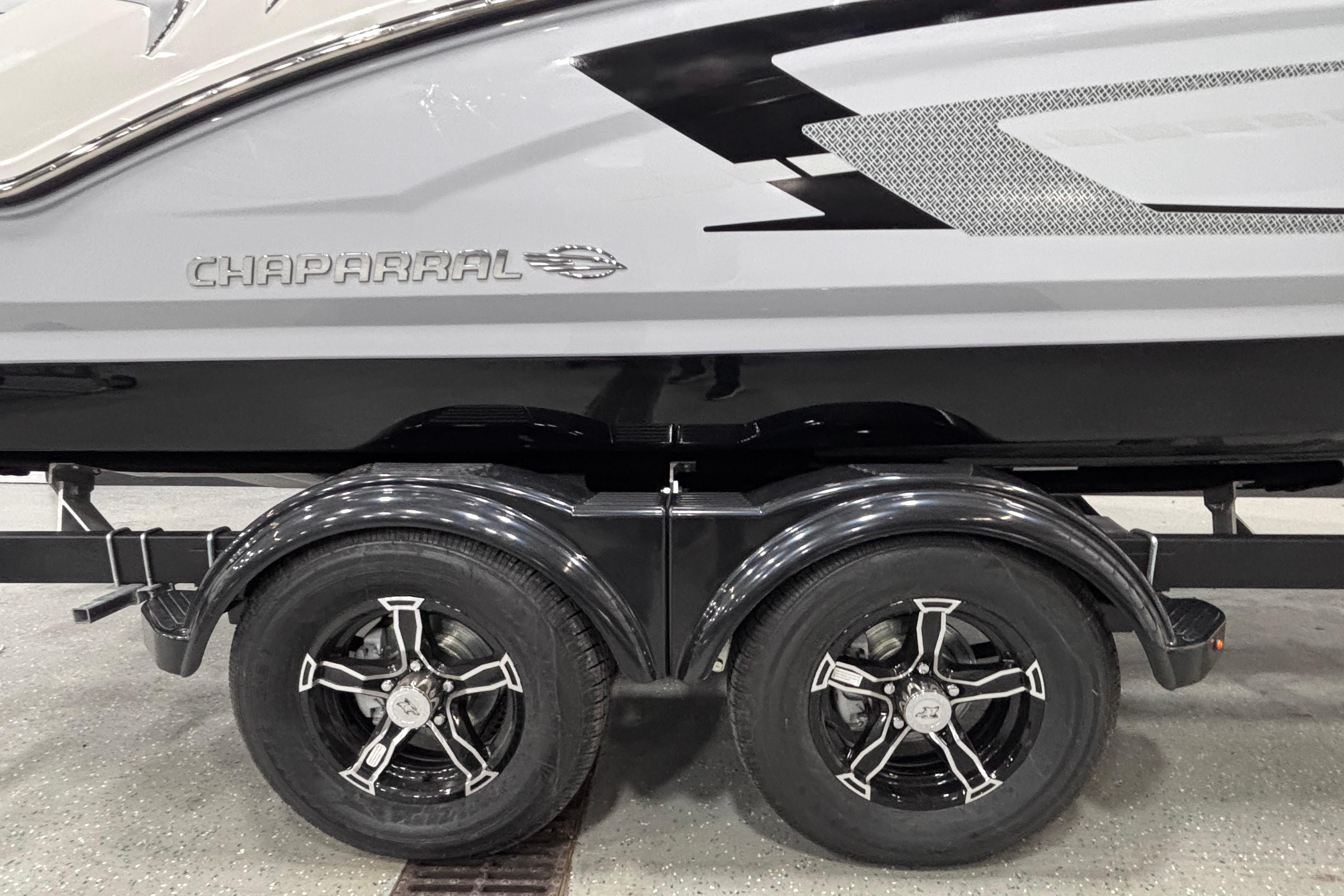 2026 Chaparral 21 SSi boat on trailer with stylish black wheels.