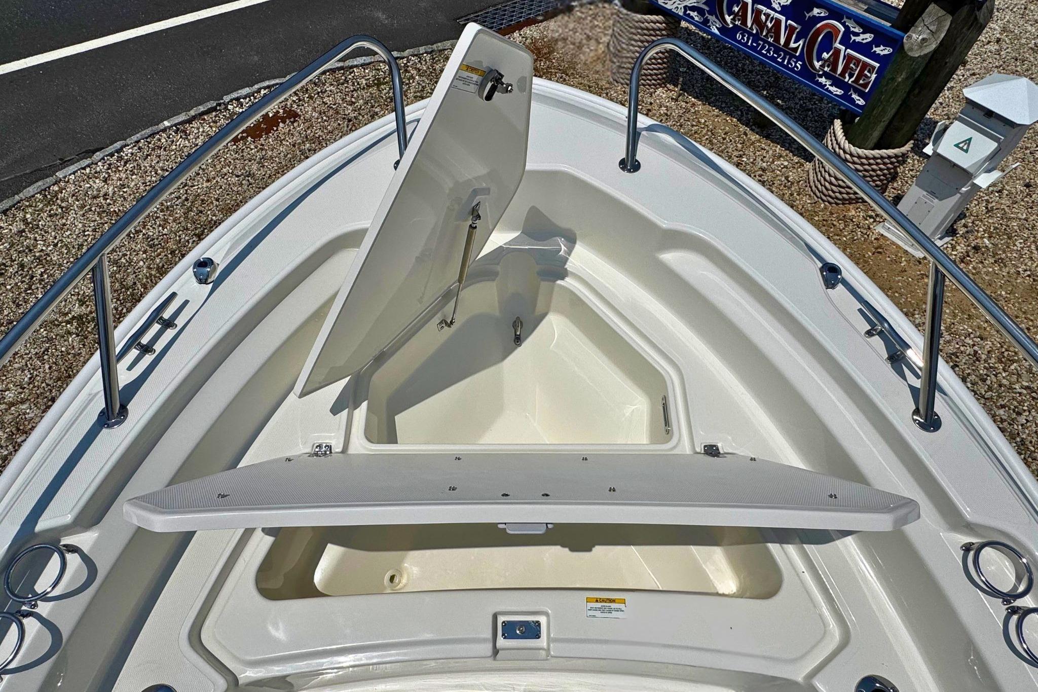 2026 Boston Whaler 220 Dauntless bow storage compartments open, showcasing spacious design.