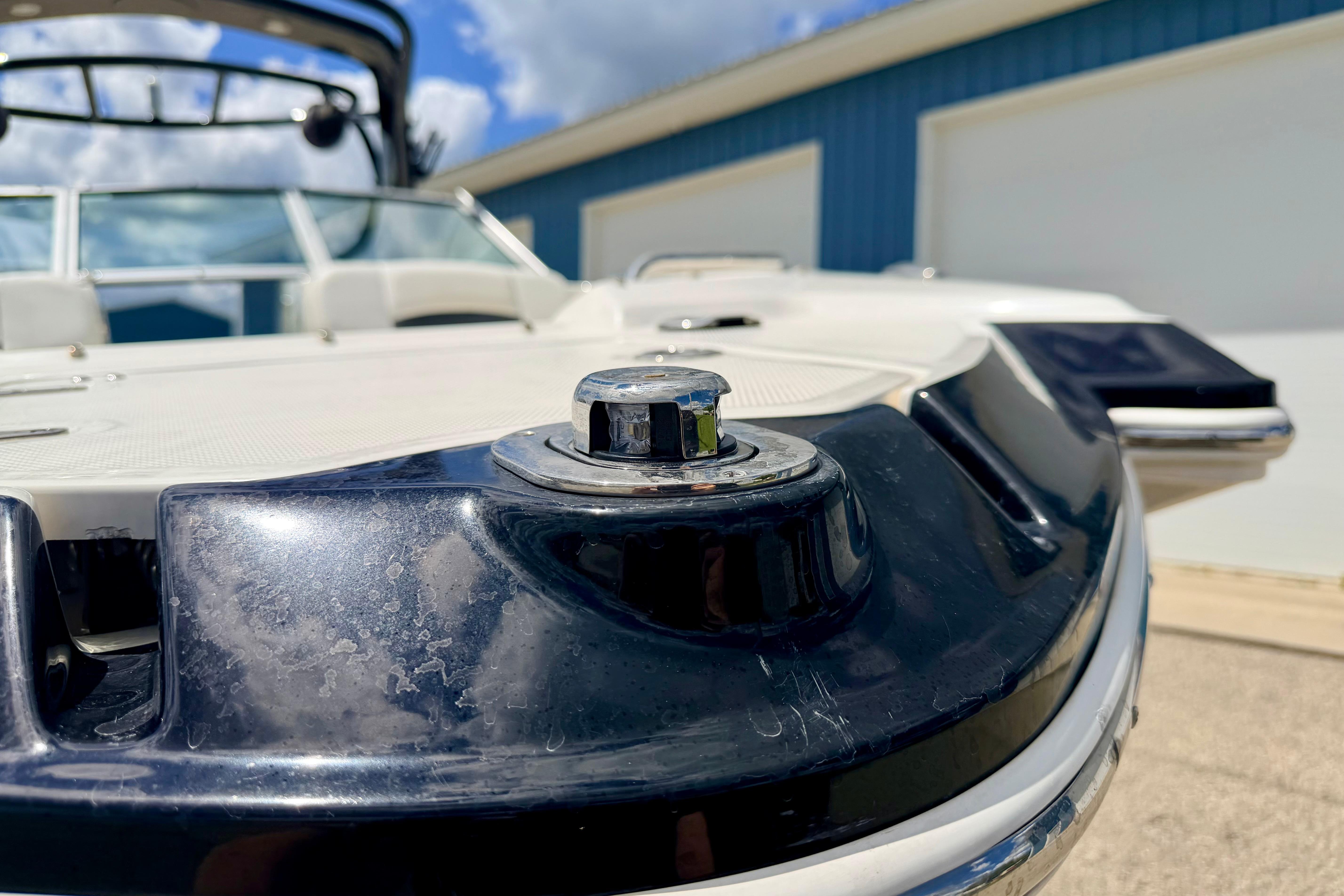 2015 Chaparral Sunesta 264 boat detail with chrome hardware, blue sky background.