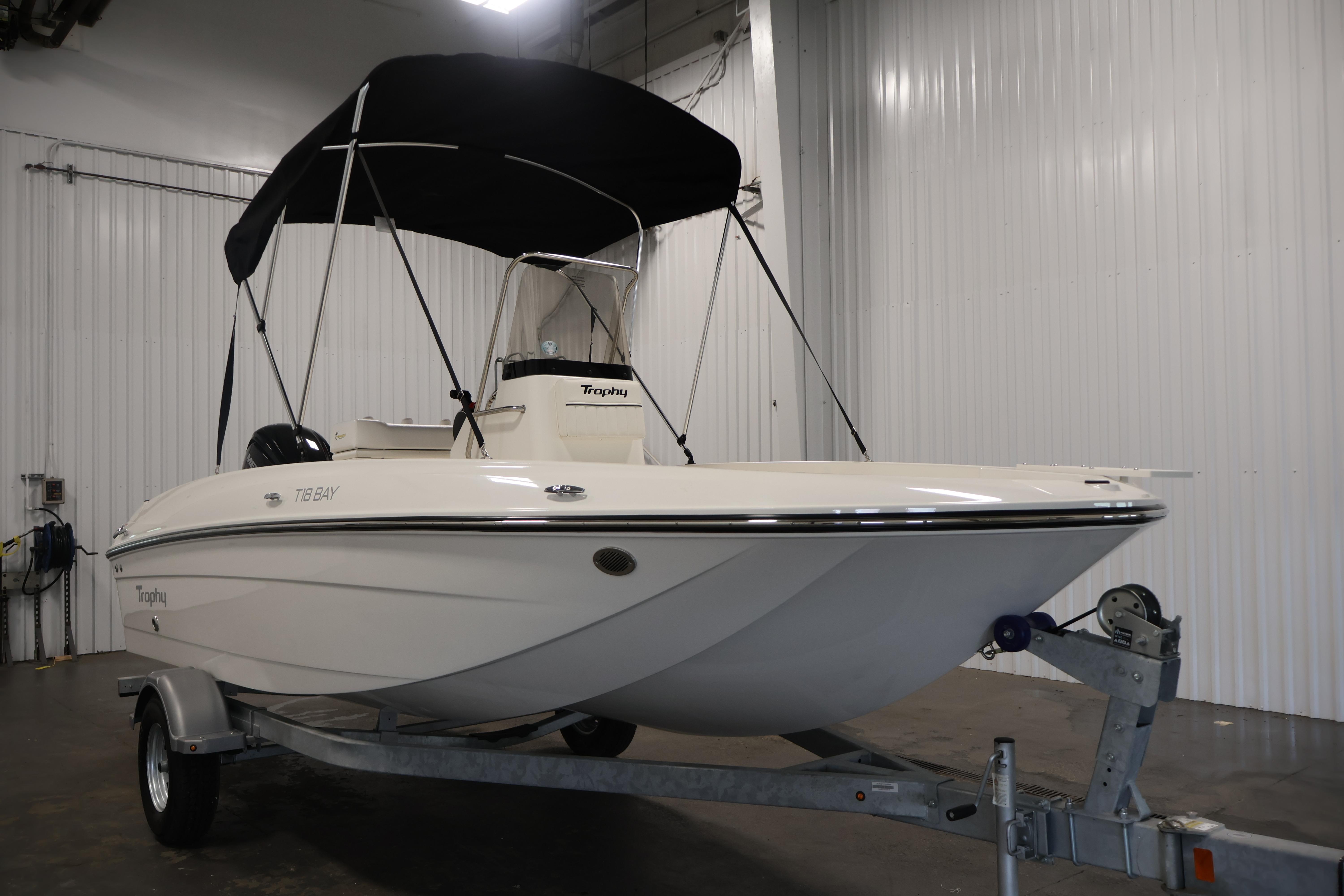2026 Bayliner Trophy T18 boat with canopy on trailer in indoor storage.