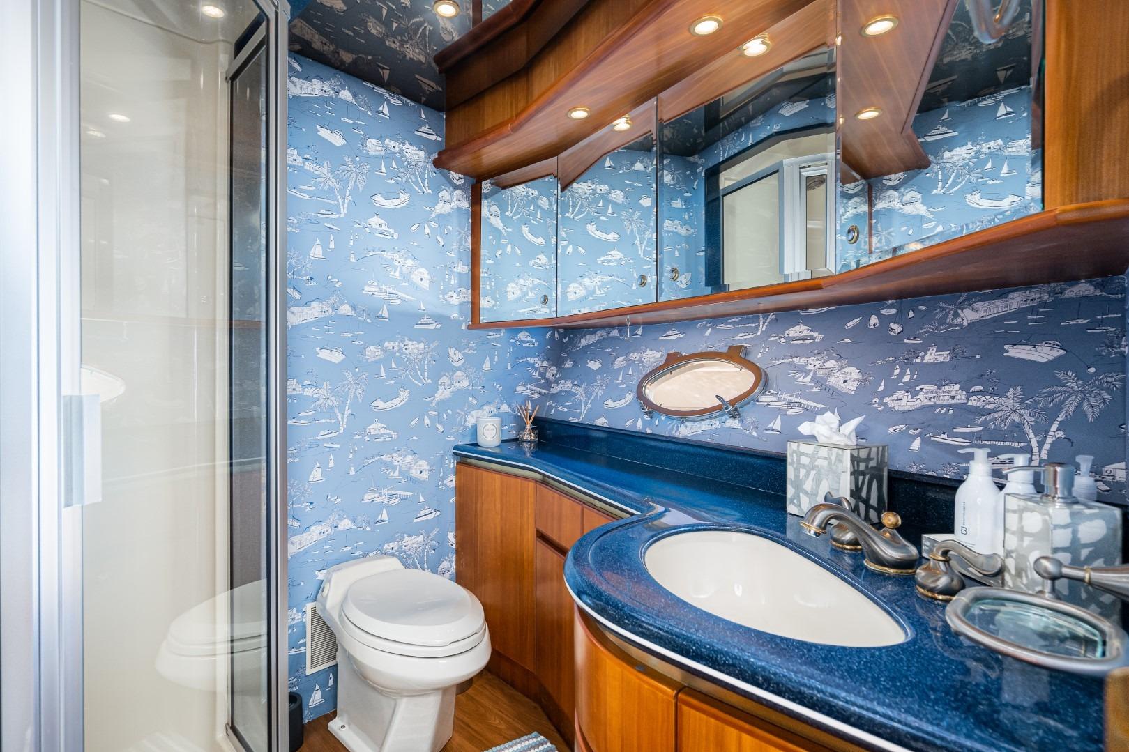 Luxurious 2001 West Bay SonShip Pilothouse bathroom with nautical-themed wallpaper and elegant fixtures.