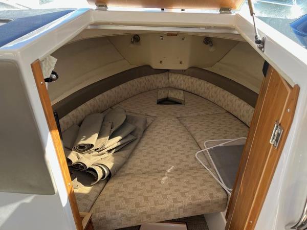 2025 Cutwater C-248 C Coupe cabin interior with beige cushions and wooden accents.