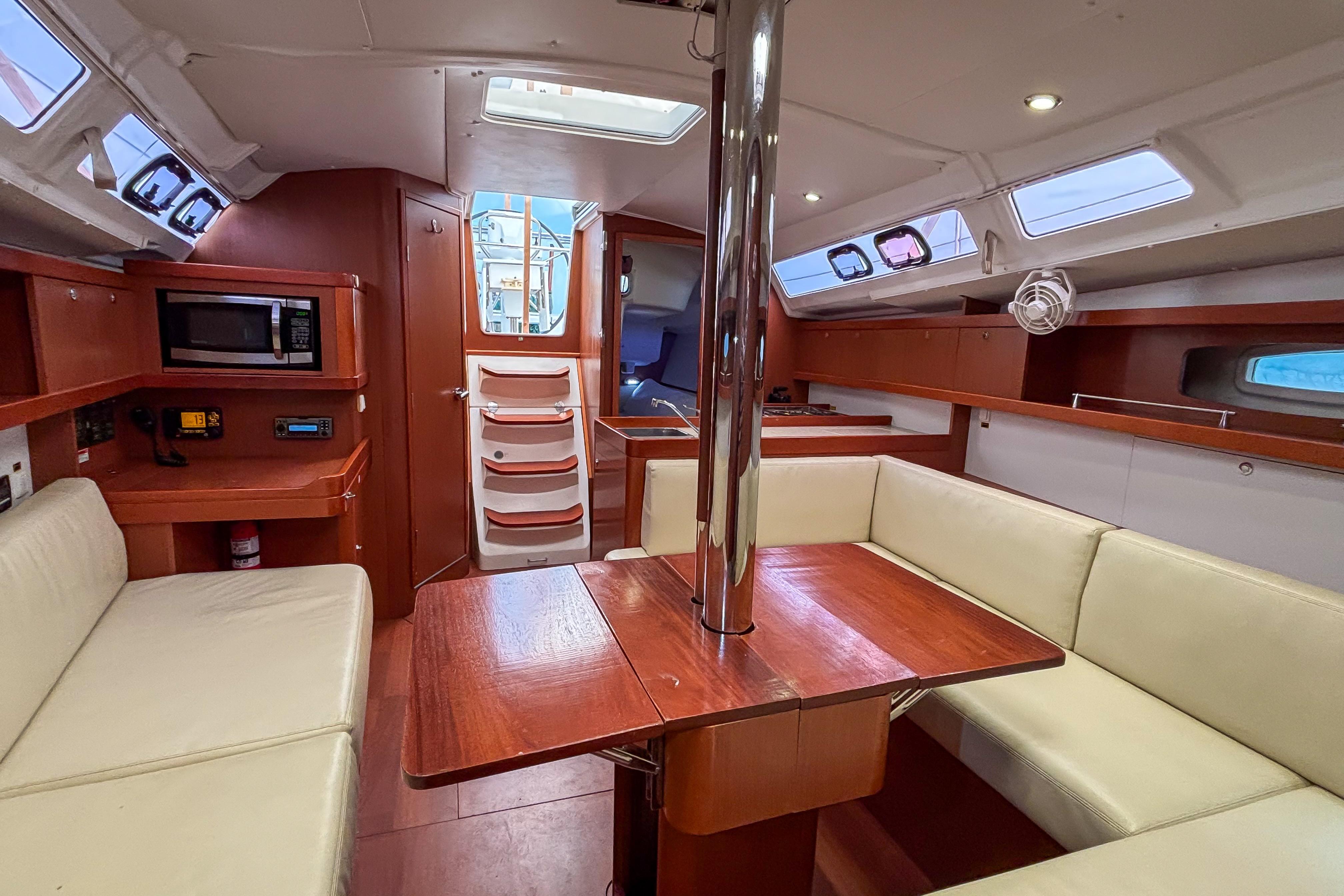 Interior of 2015 Beneteau Oceanis 37 sailboat with dining area and kitchenette.