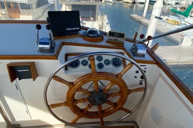 Helm of 1977 Grand Banks 42 yacht with wooden wheel and navigation instruments.