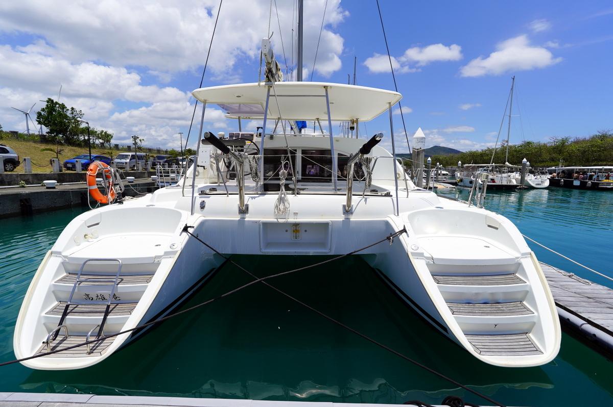 2013 Lagoon 380 catamaran docked in a marina under a partly cloudy sky.